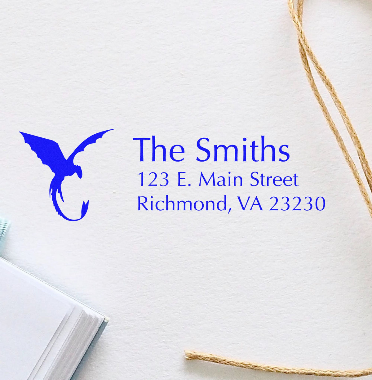 Blue custom stamp and seal with eagle logo, The Smiths return address on white paper, framed by twine.
