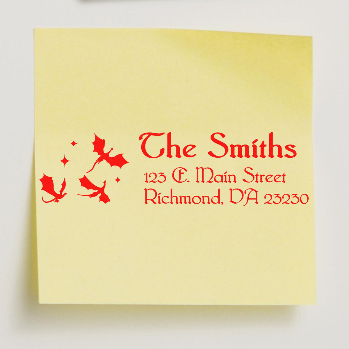 Pale yellow custom address stamp with red text and holly accents for The Smiths, 123 E. Main Street, Richmond, VA 23230.