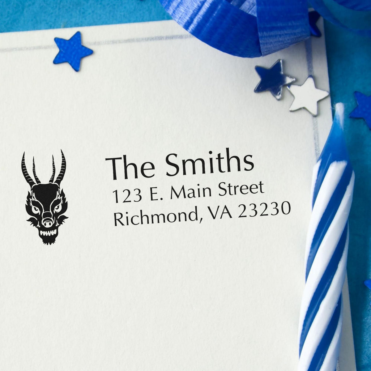 Custom stamp and seal products on a white envelope with blue ribbon, star seals, and The Smiths address.