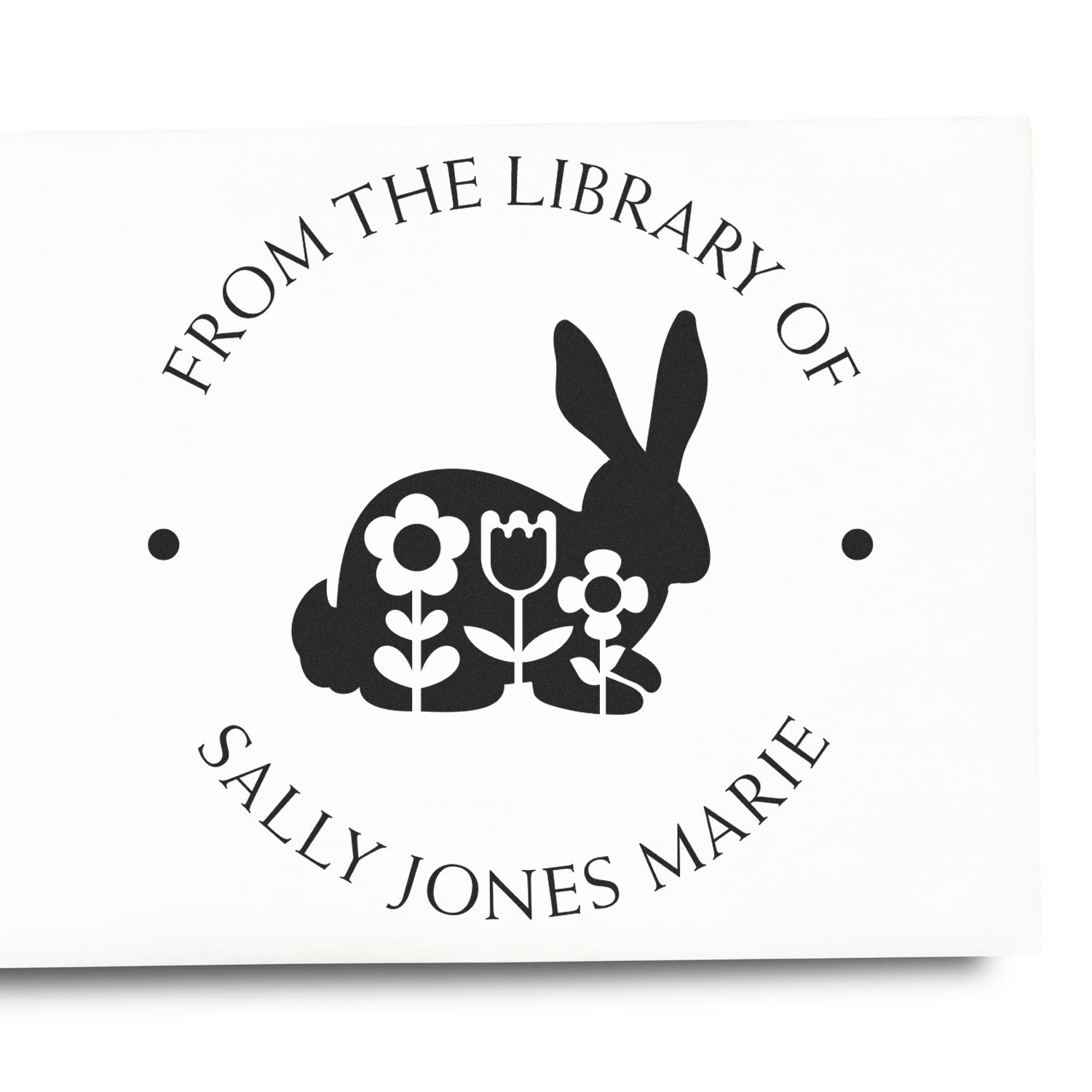 Black custom library stamp seal with rabbit and flowers on white, reading From the Library of Sally Jones Marie.