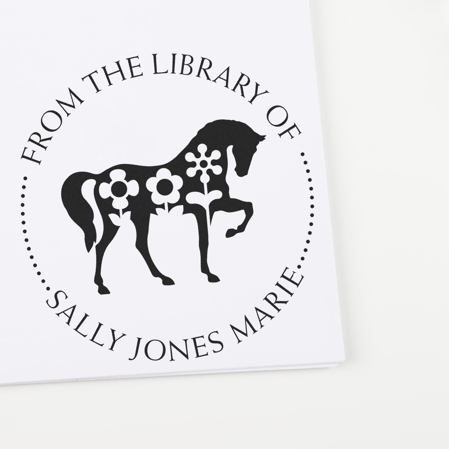 Black custom library book stamp with horse silhouette and floral details, reading From the Library of Sally Jones Marie