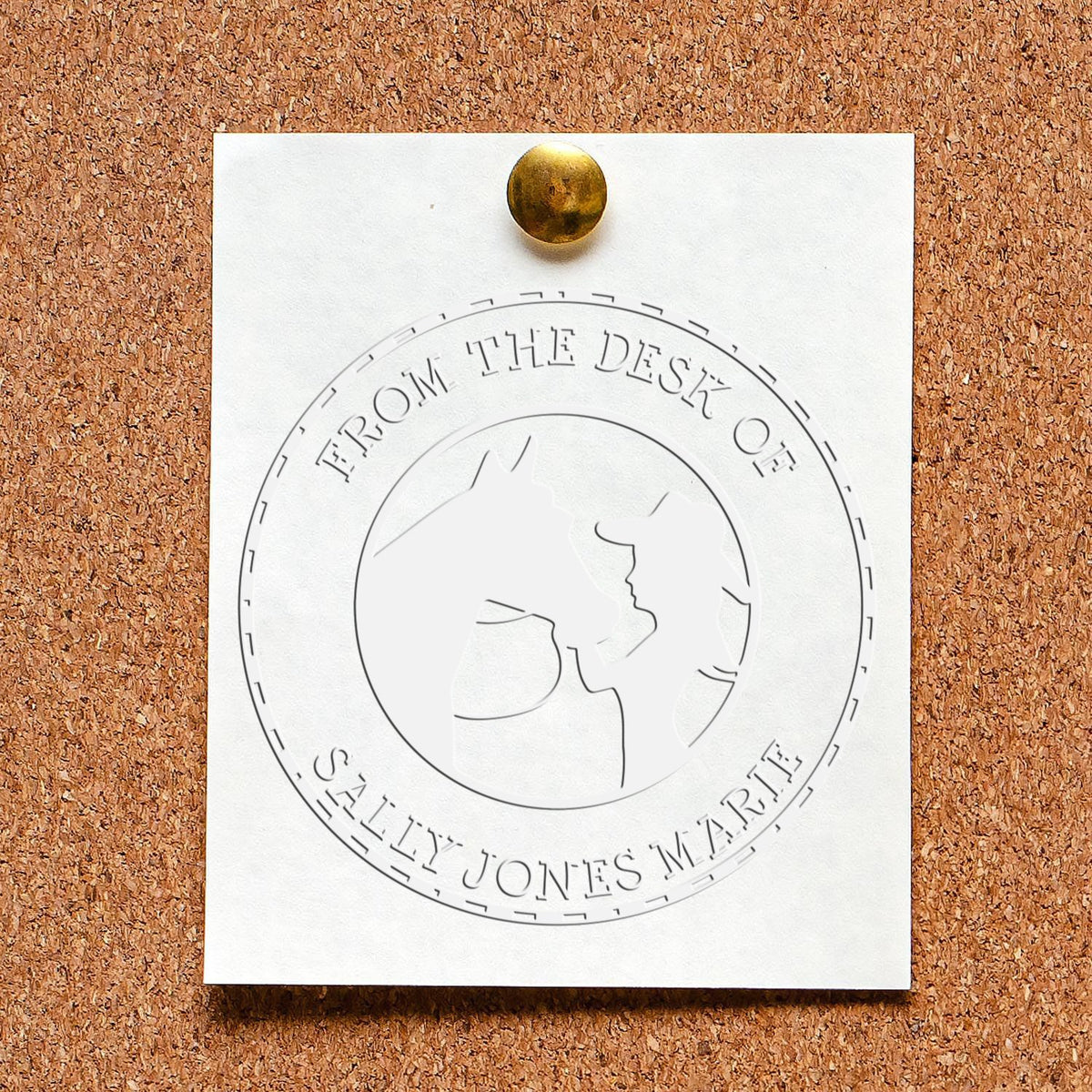 White embossed desk seal stamp on corkboard, pinned with brass tack, featuring a circular horse-head seal design.