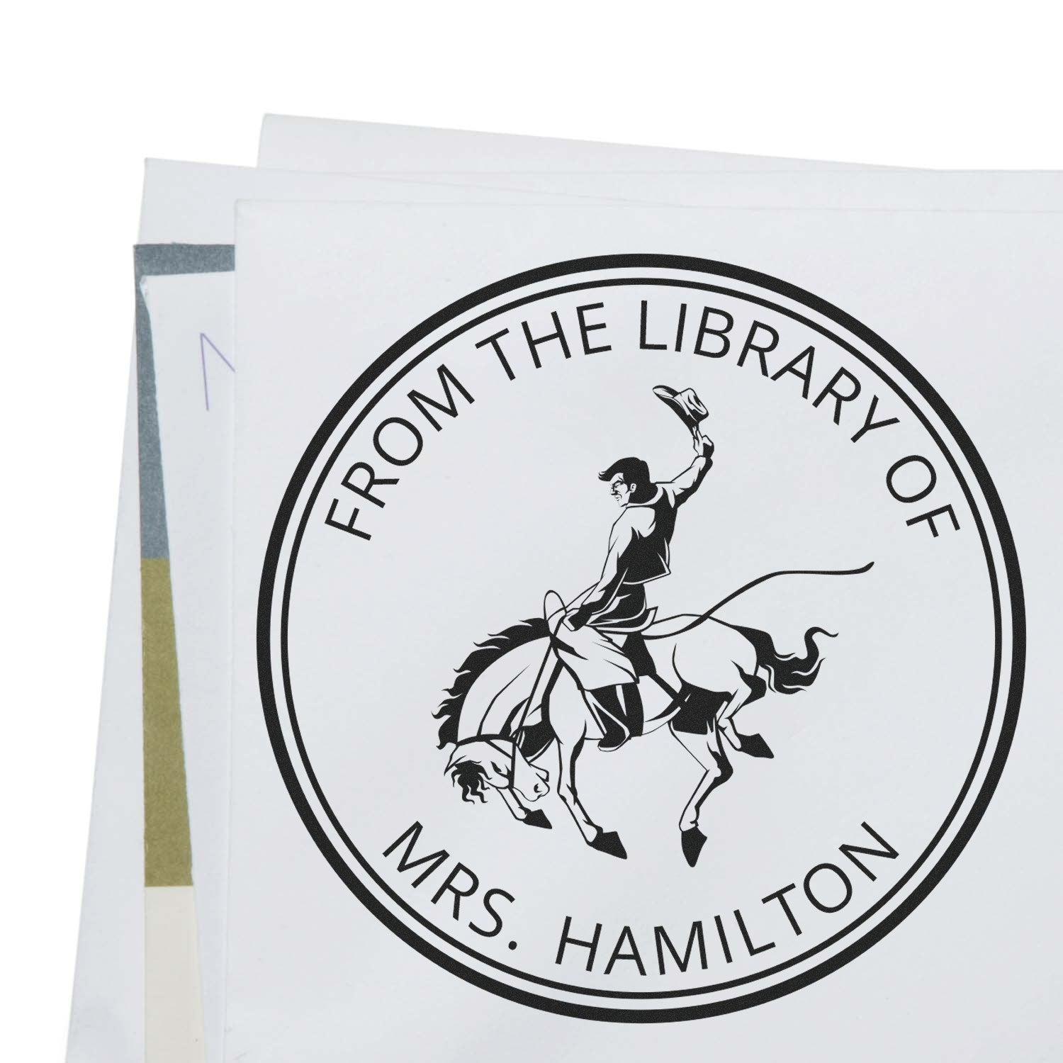 Stacked white sheets with a black custom library stamp seal reading From the Library of Mrs. Hamilton and a rodeo rider.