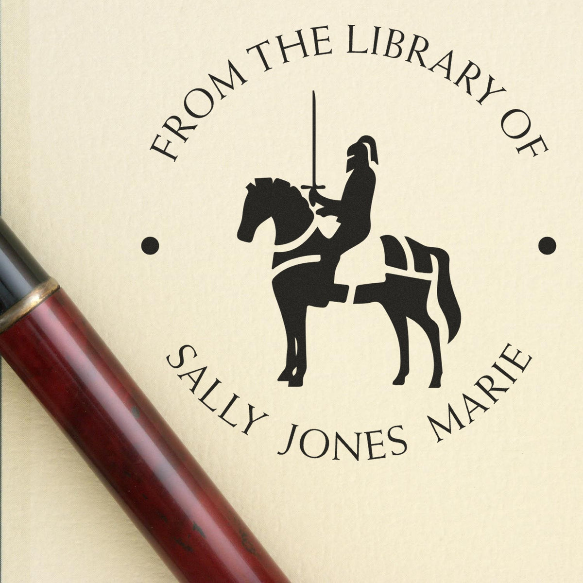 Custom library book stamp and seal with black knight logo, cream background, and red-brown handle reading From the Library of Sally Jones Marie
