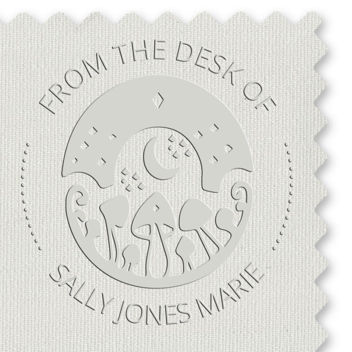 White and gray embossed stamp seal with circular mushroom design and From the Desk of Sally Jones Marie text.