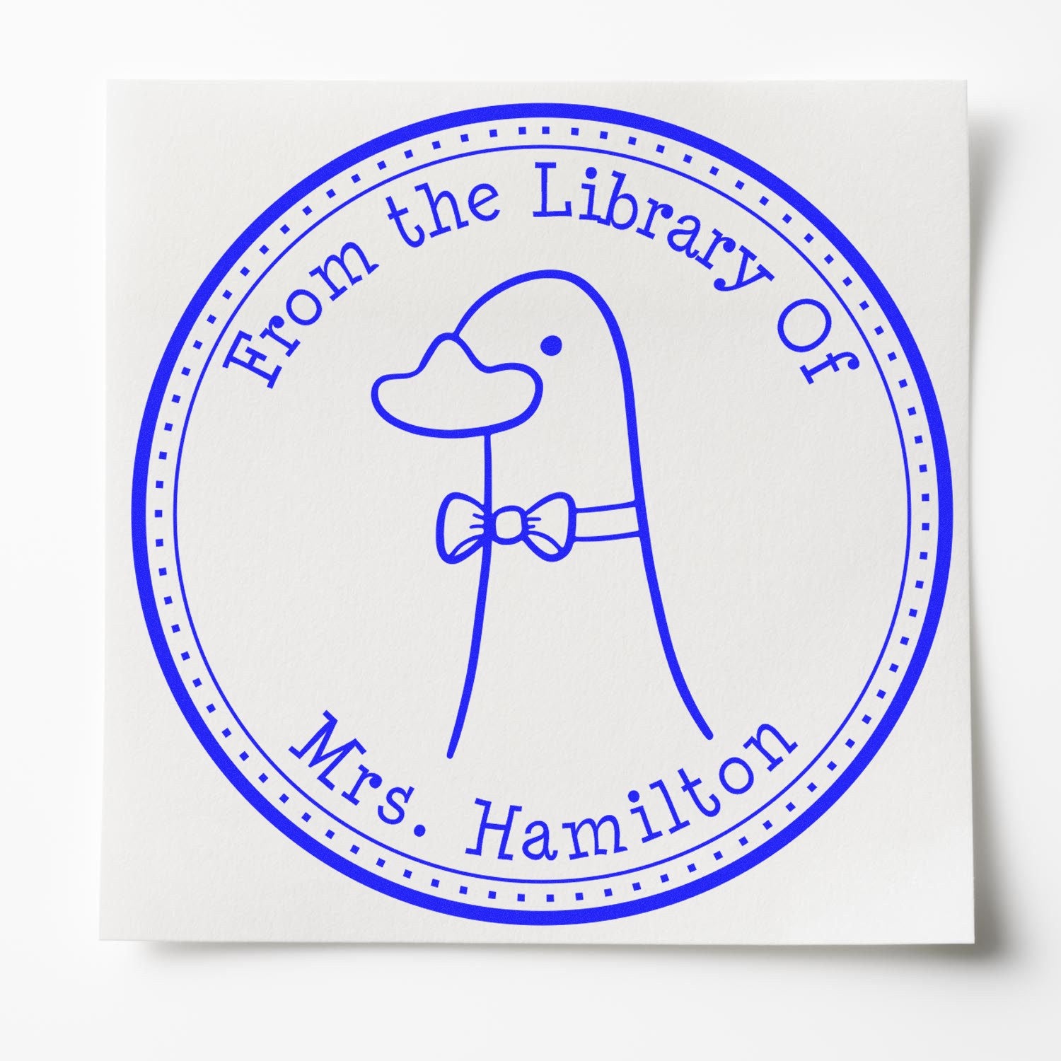 DoodleDuck cartoon animal pre-inked ex libris bookplate stamp featuring a duck with a bow tie, encircled by the text "From the Library Of Mrs. Hamilton." Ideal for personalized new address stamp use.