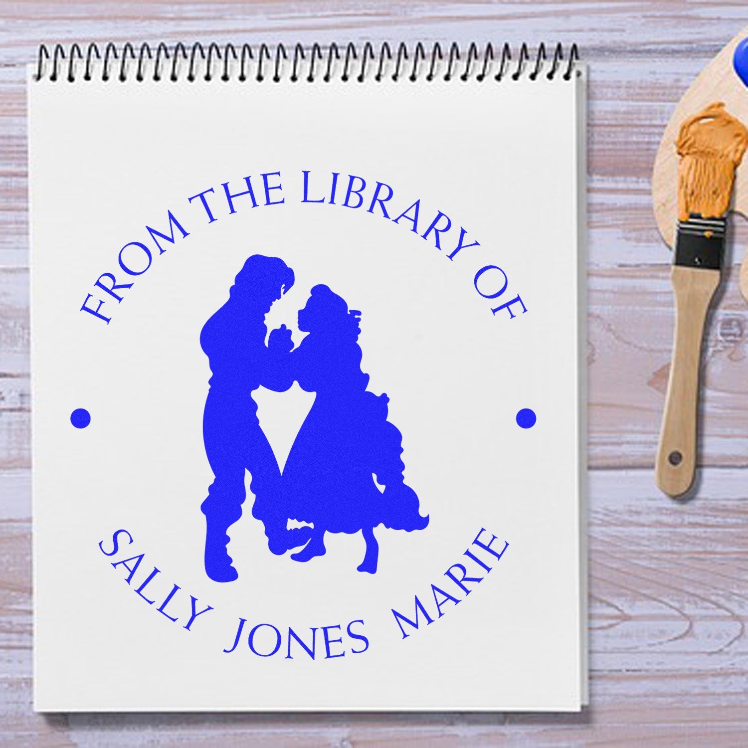 Blue custom self-inking library stamp and seal on white notebook, with silhouette and From the Library of Sally Jones Marie.