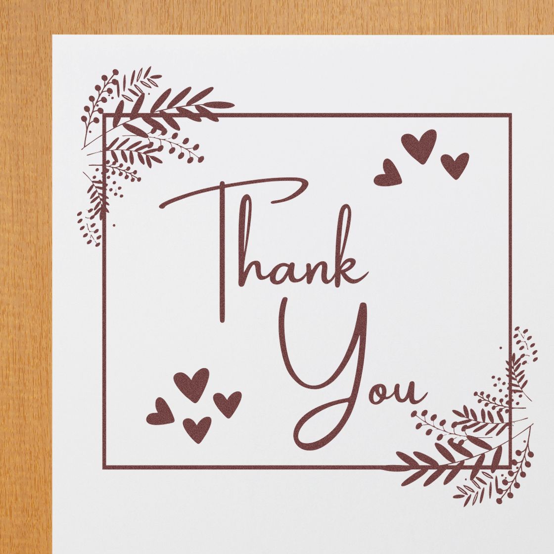Brown thank you stamp seal design with hearts and leafy corners on white paper background.