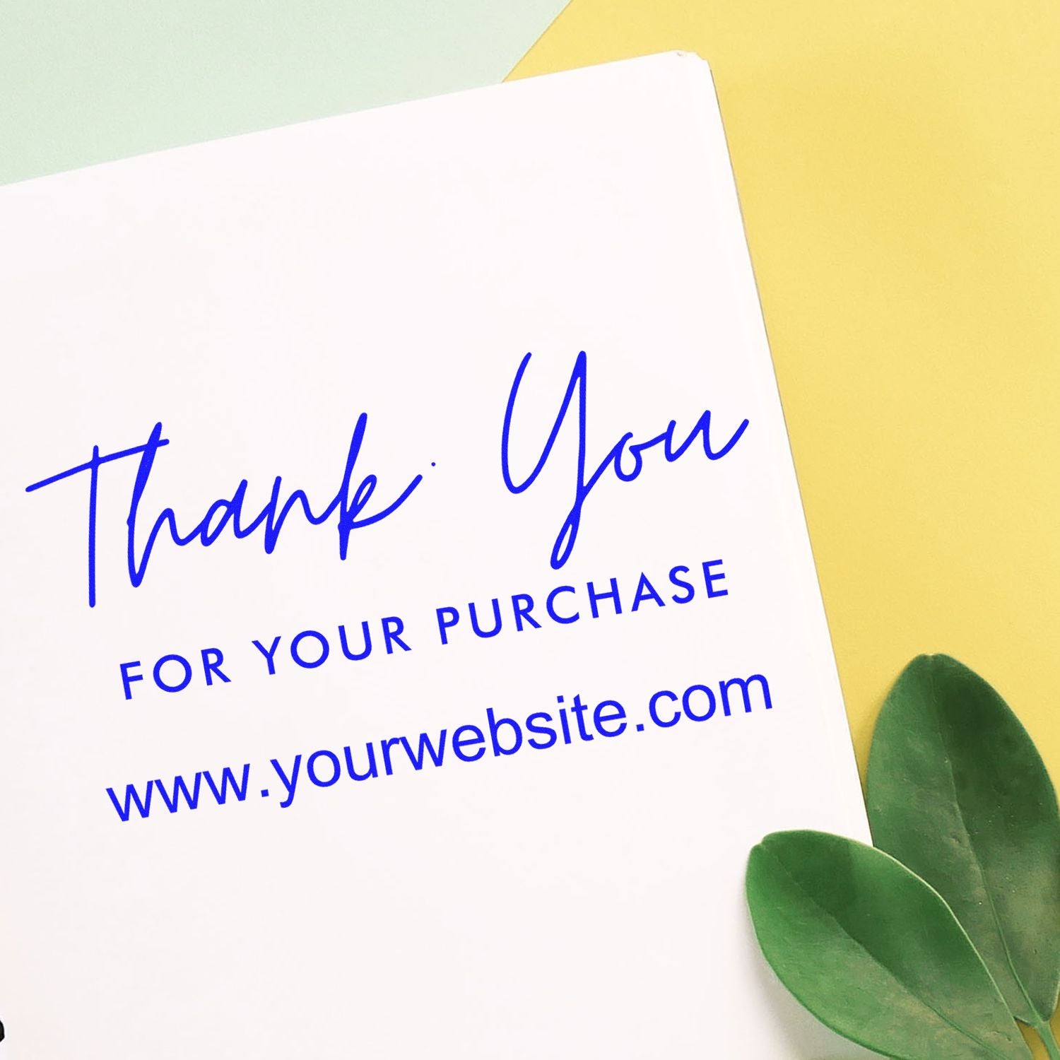 Blue thank you stamp and seal on white card with website text, set on a yellow background with green leaves.
