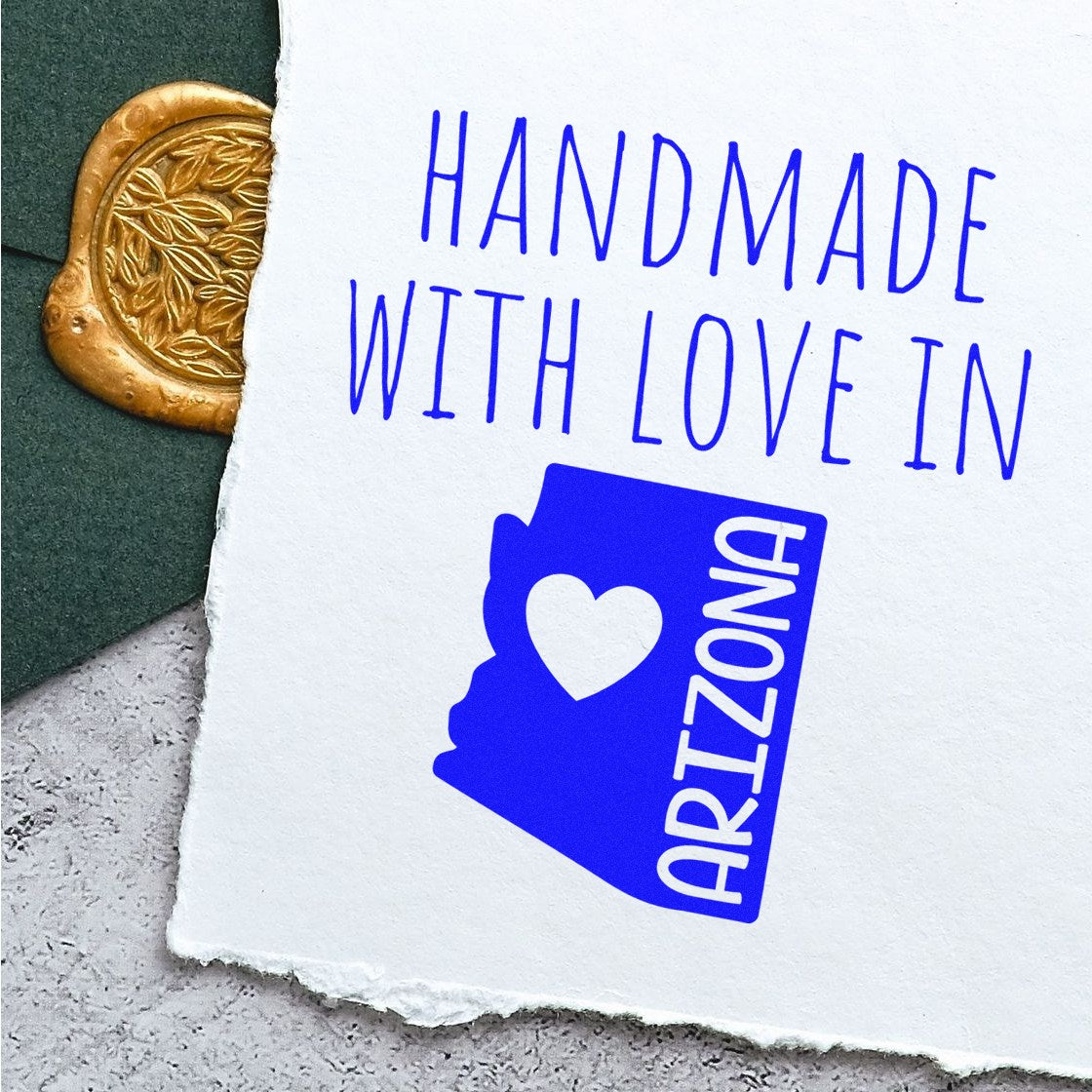 Wood Handle Arizona Handmade with Love Rubber Stamp on white paper, featuring blue text and a heart within the Arizona state outline, next to a decorative gold wax seal.