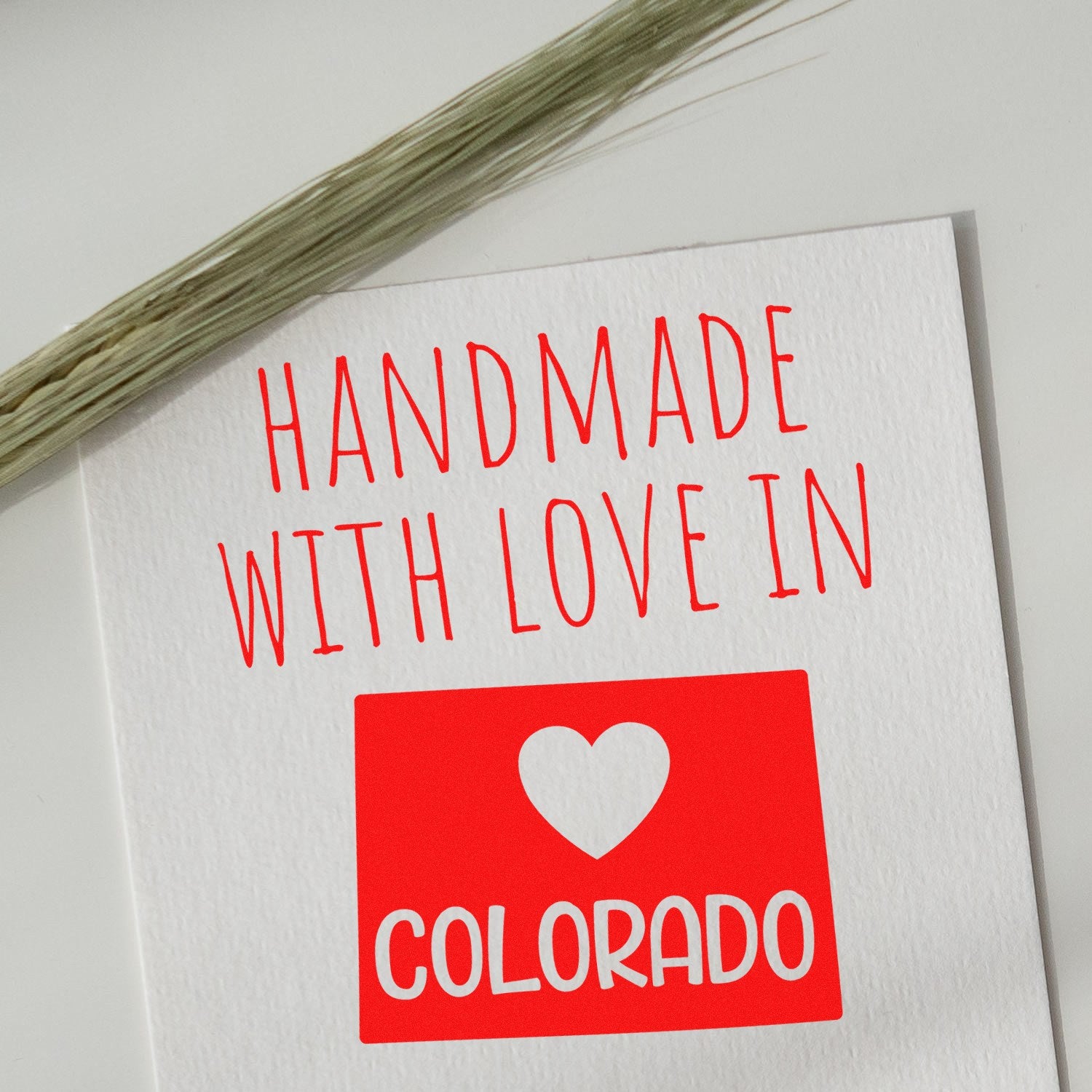 Handmade with Love in Colorado Slim Pre-Inked Stamp on white paper, featuring red text and a heart design, perfect for adding a personal touch to crafts and gifts.