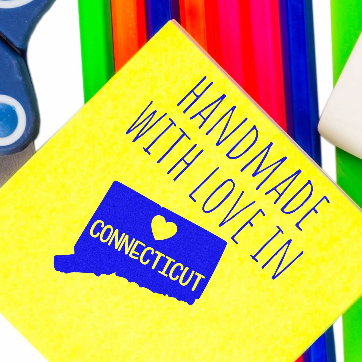 Self-Inking Connecticut Handmade with Love Stamp on a vibrant yellow background, featuring a blue state outline and heart design, surrounded by colorful stationery items.