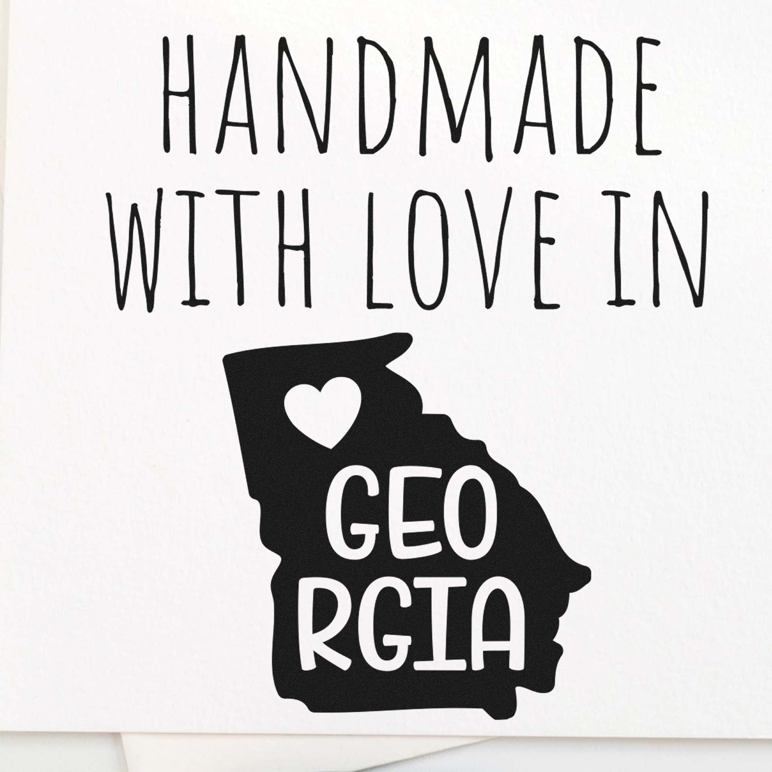 Self-Inking Georgia Handmade with Love Stamp featuring a heart and Georgia state outline, perfect for crafts and gifts. Black ink on white background.