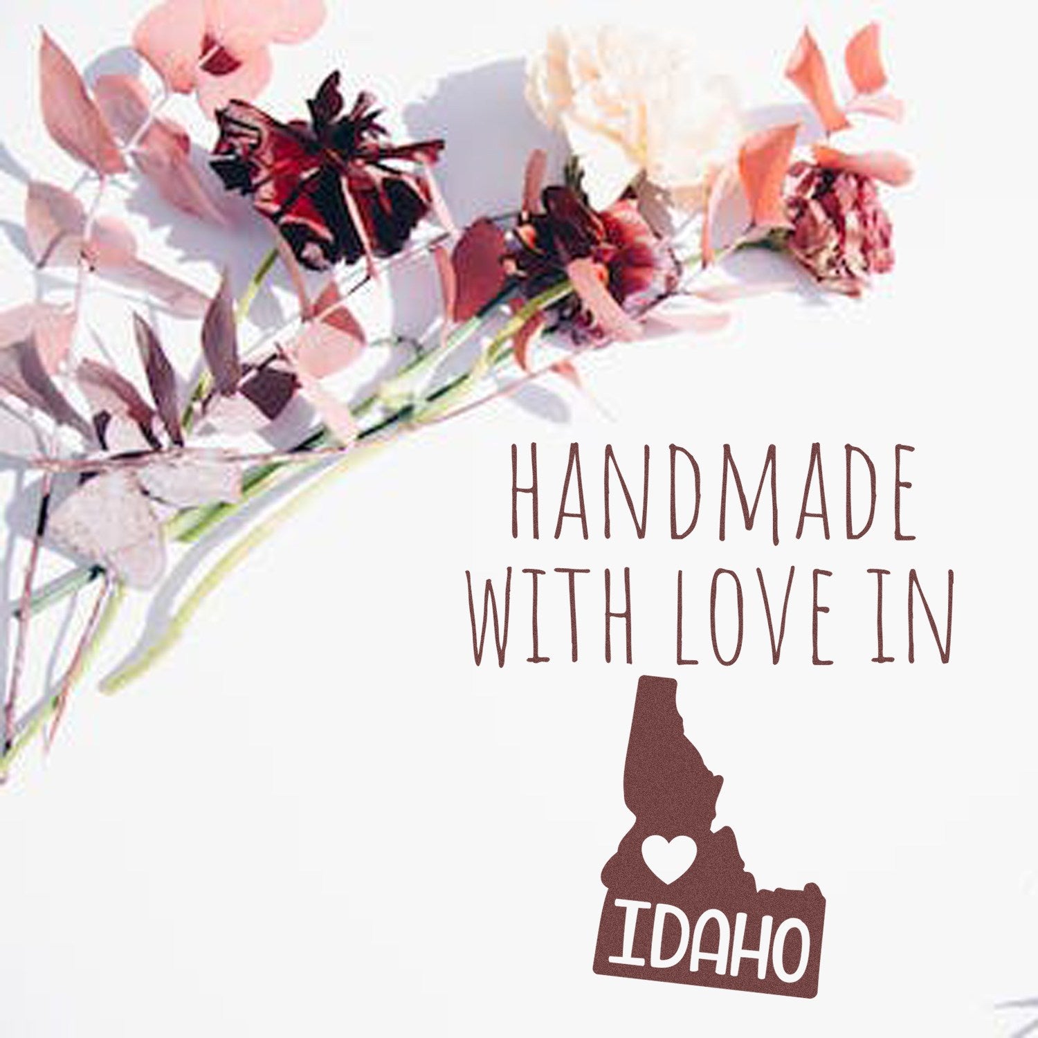 Wood Handle Idaho Handmade with Love Rubber Stamp on a white background, featuring a heart and the word Idaho inside the state outline, surrounded by pink and red flowers.