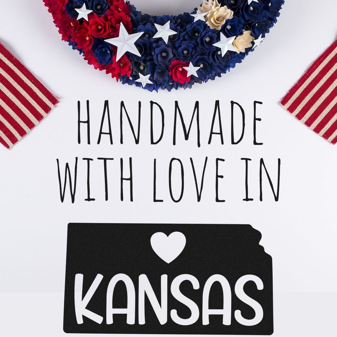 Self-Inking Kansas Handmade with Love Stamp featuring a heart and state outline, perfect for crafts and gifts. Includes patriotic elements like stars and stripes in the background.