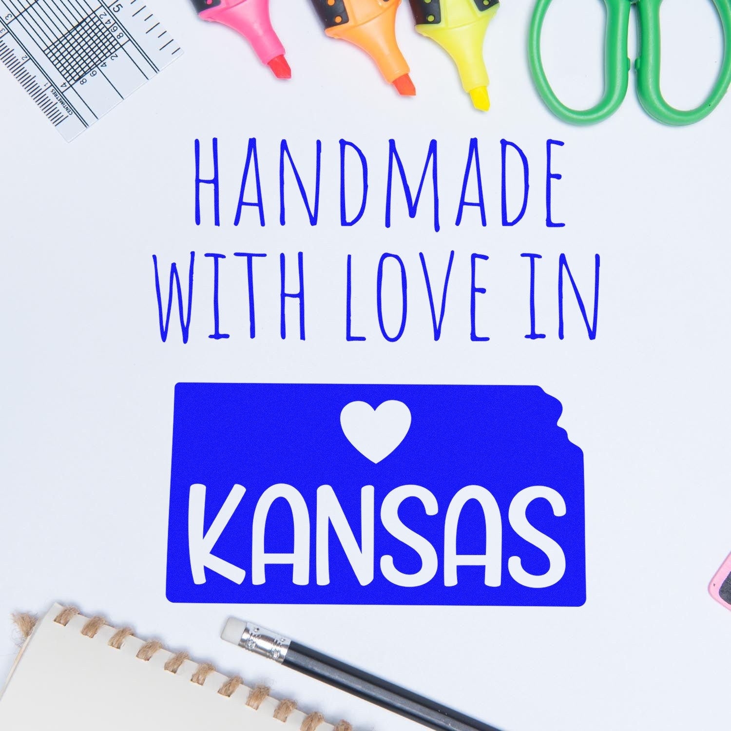 Wood Handle Kansas Handmade with Love Rubber Stamp on a desk with colorful stationery, featuring a blue Kansas state outline and heart design. Perfect for crafts and personalized projects.