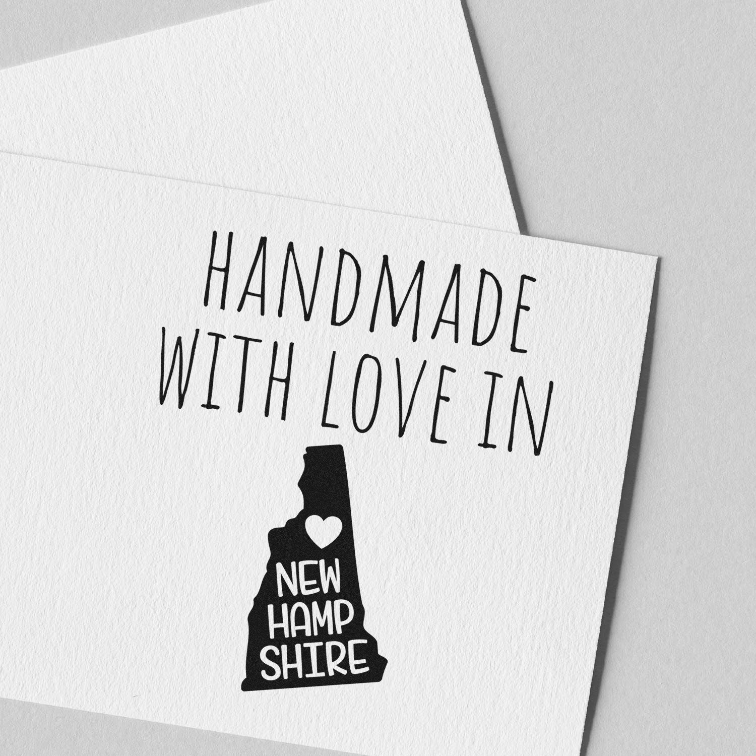 Wood Handle New Hampshire Handmade with Love Rubber Stamp on white paper, featuring a heart and state outline, perfect for crafts and gifts.