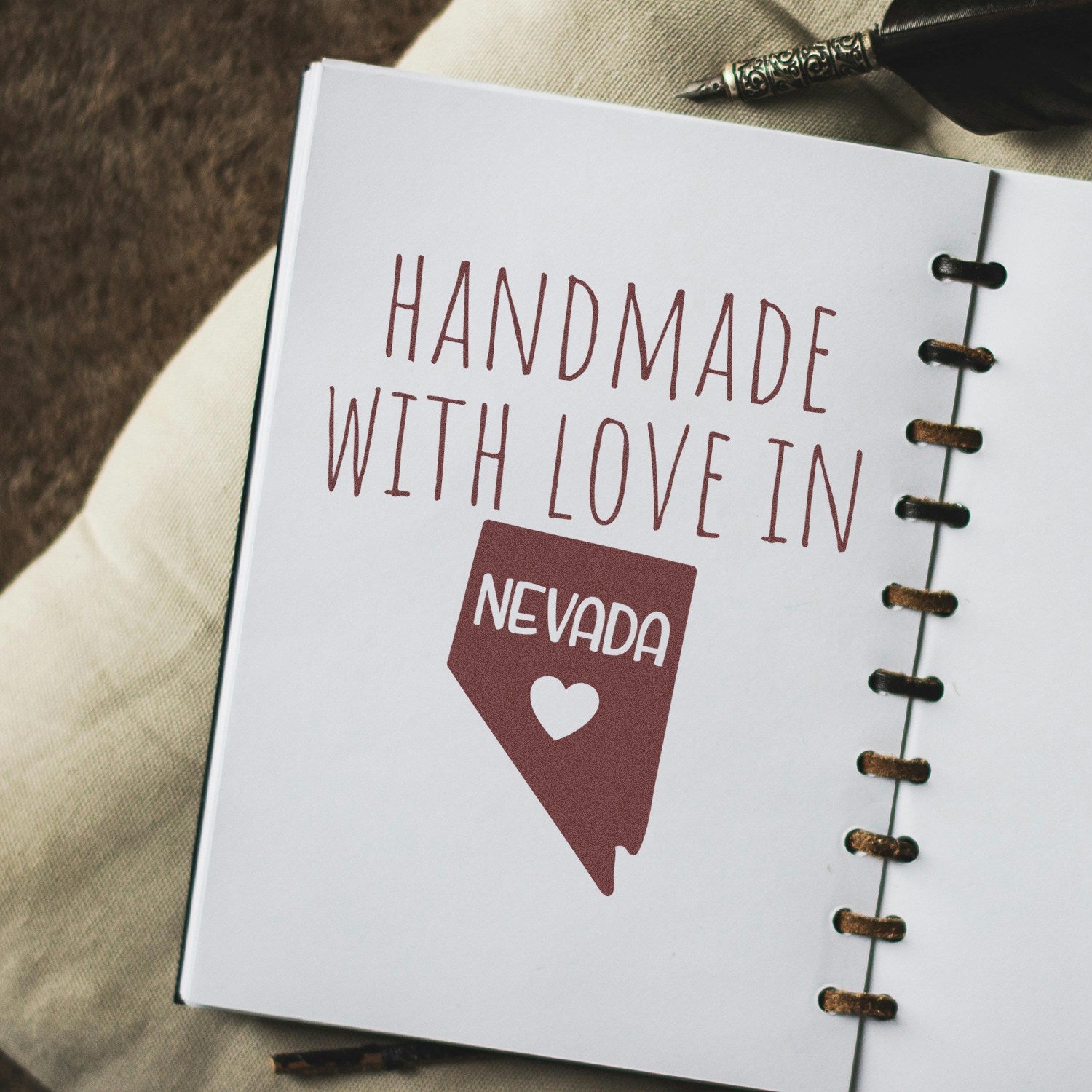 Self-Inking Nevada Handmade with Love Stamp on paper, featuring a Nevada state outline and heart, perfect for crafts and gifts. Durable design with clear impressions.