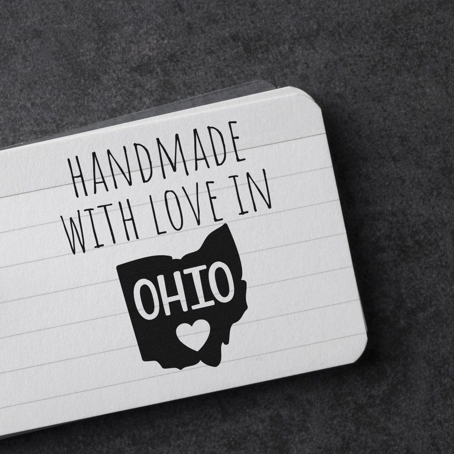 Self-Inking Ohio Handmade with Love Stamp on a notepad, featuring a heart inside the Ohio state outline, perfect for adding a personal touch to crafts and gifts.