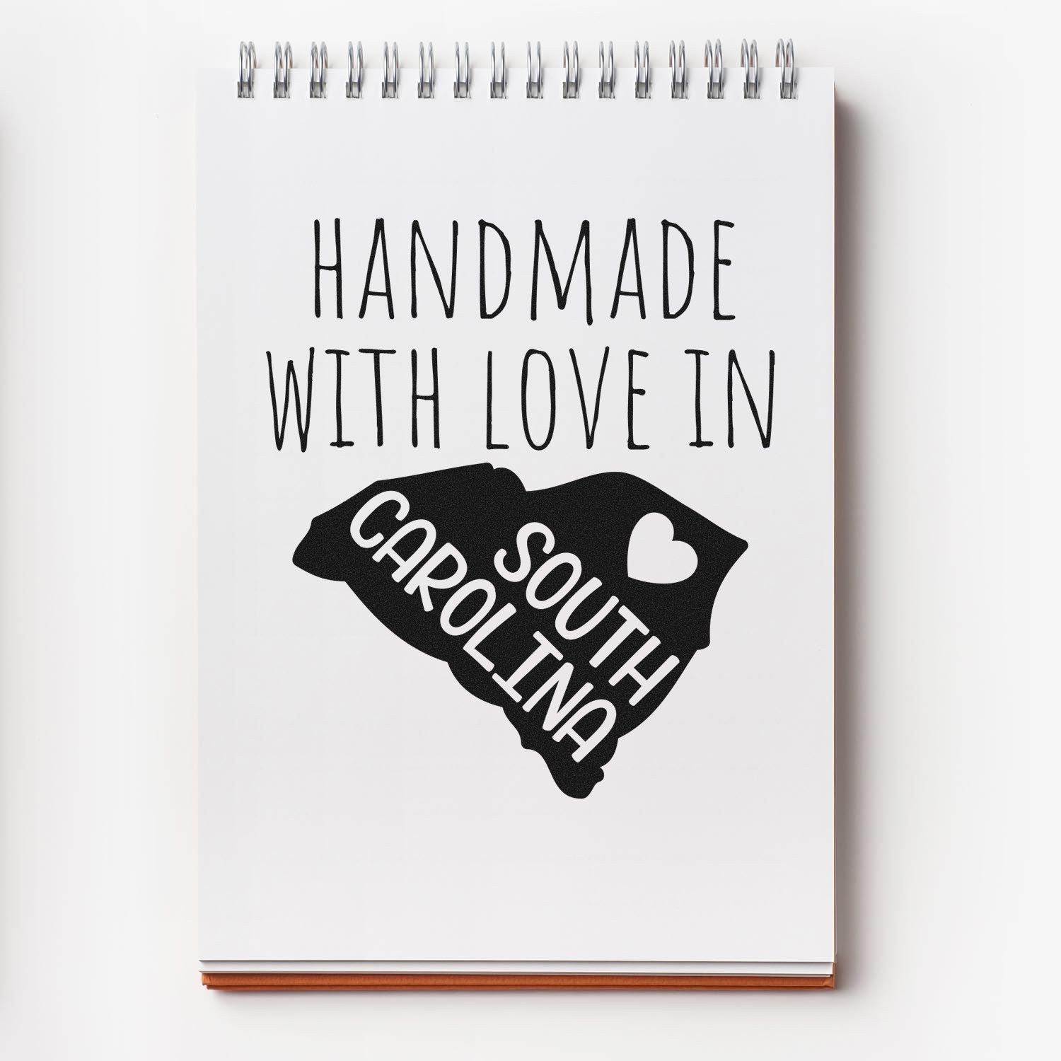 Handmade with Love in South Carolina Slim Pre-Inked Stamp on notepad, featuring a heart and state outline design.