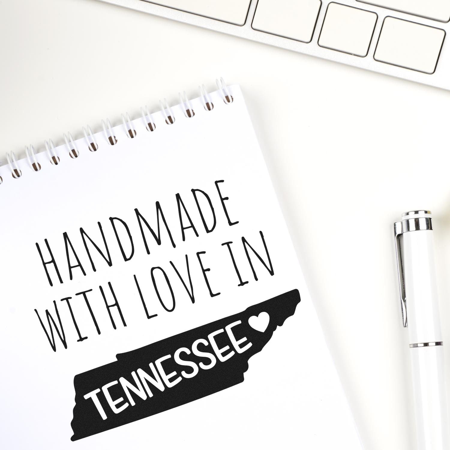 Wood Handle Tennessee Handmade with Love Rubber Stamp on a notepad, featuring a black Tennessee state outline with Handmade with Love in Tennessee text. Perfect for crafts and gifts.