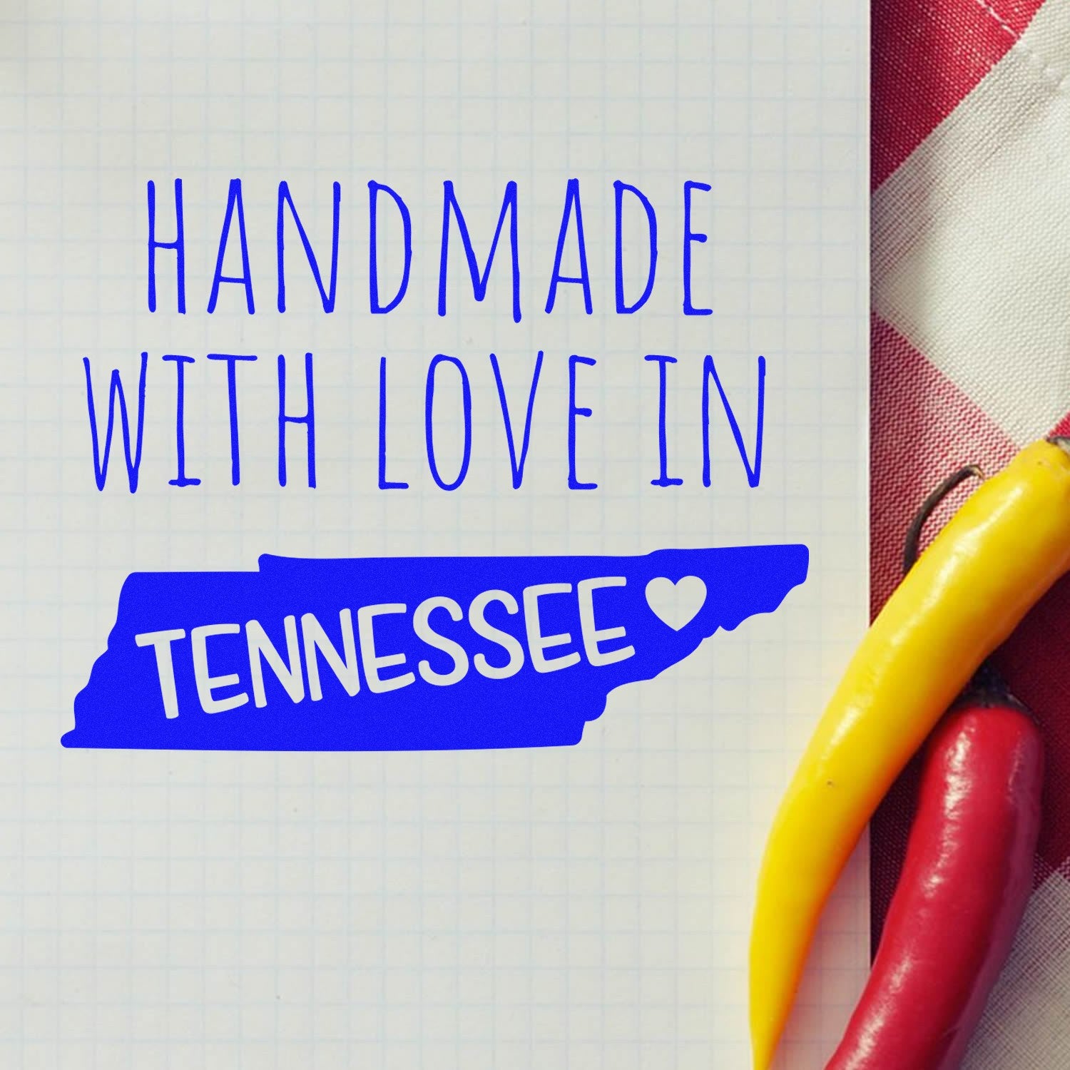 Handmade with Love in Tennessee Slim Pre-Inked Stamp on grid paper with red and yellow peppers, featuring blue text and a heart symbol.