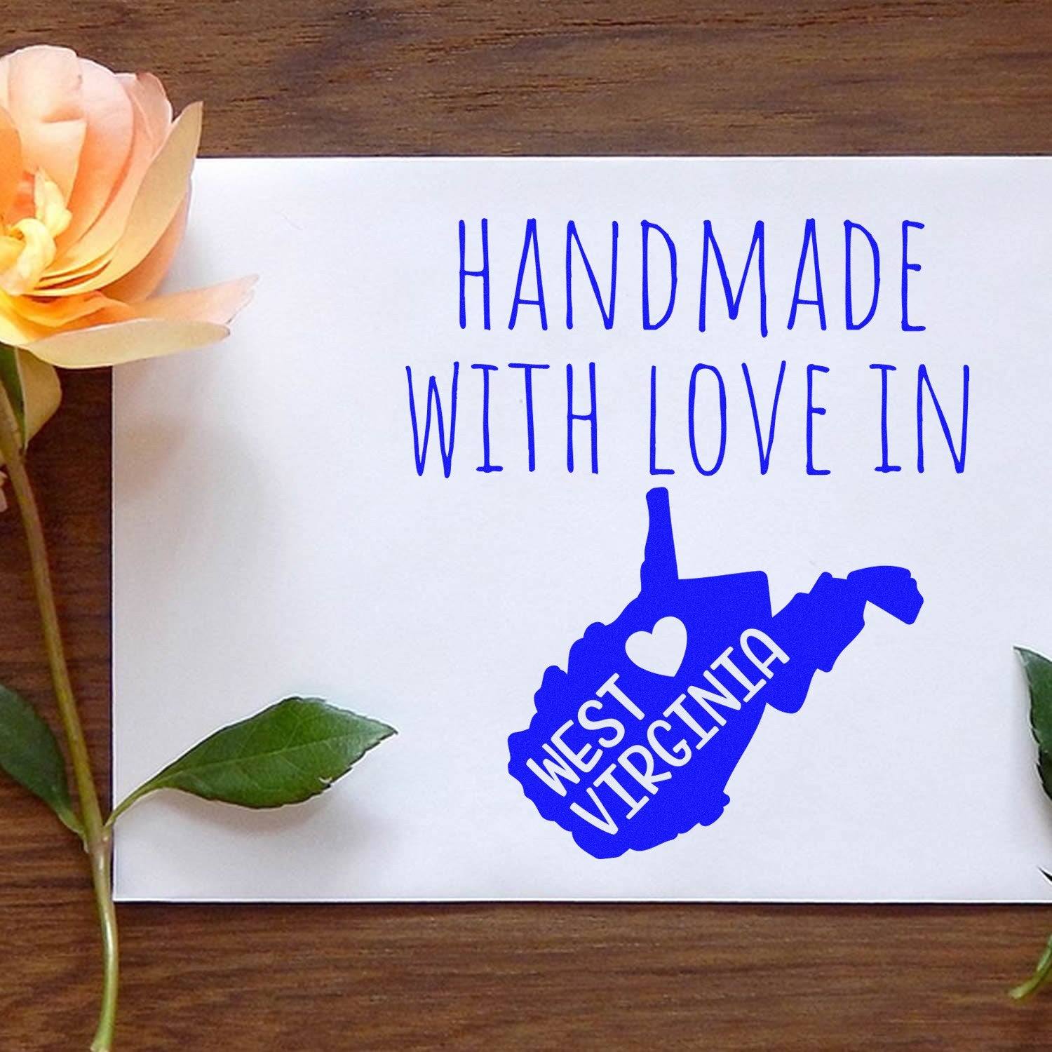 Wood Handle West Virginia Handmade with Love Rubber Stamp on white paper, featuring blue text and a heart design. Perfect for crafts and personalized gifts.