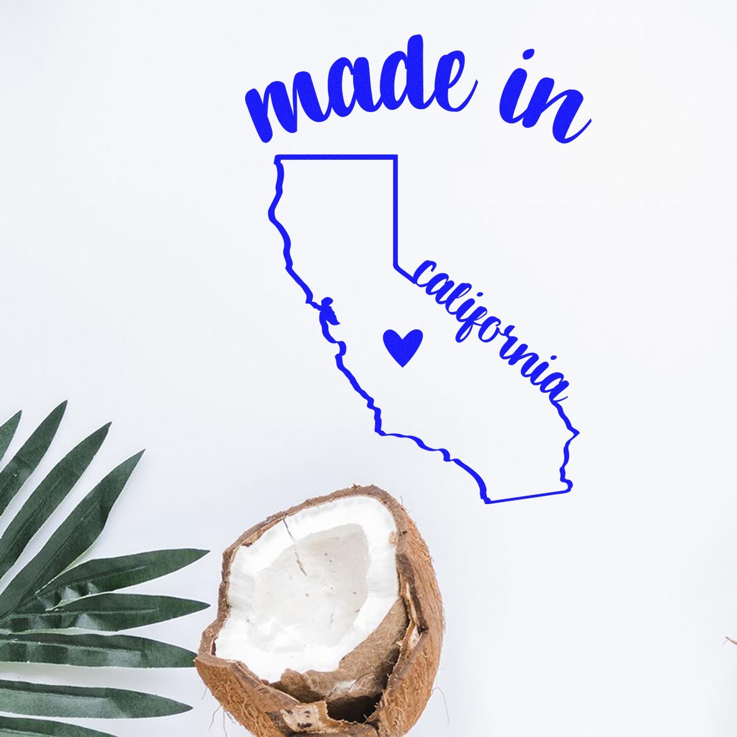 Made with Love in California Rubber Stamp featuring a blue outline of California with 'made in' and 'california' text, next to a halved coconut and palm leaf on a white background.