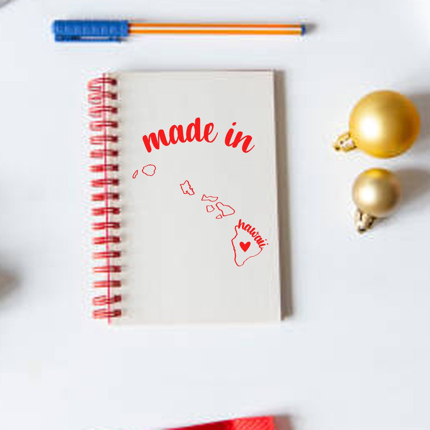 Self-Inking Handmade with Love in Hawaii Stamp on a notebook, featuring a red spiral binding and made in Hawaii design. Perfect for adding a personal touch to crafts and gifts.