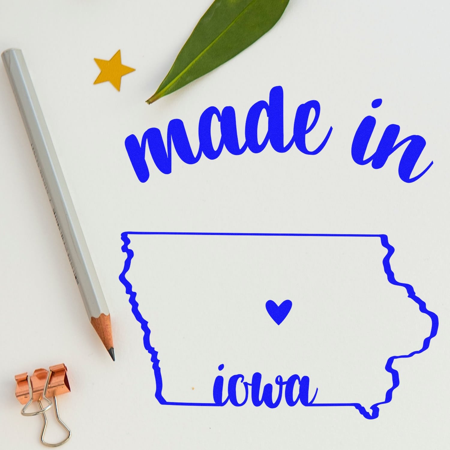 Self-Inking Handmade with Love in Iowa Stamp featuring a blue outline of Iowa with a heart, surrounded by a pencil, leaf, and star. Perfect for crafts and personalized projects.