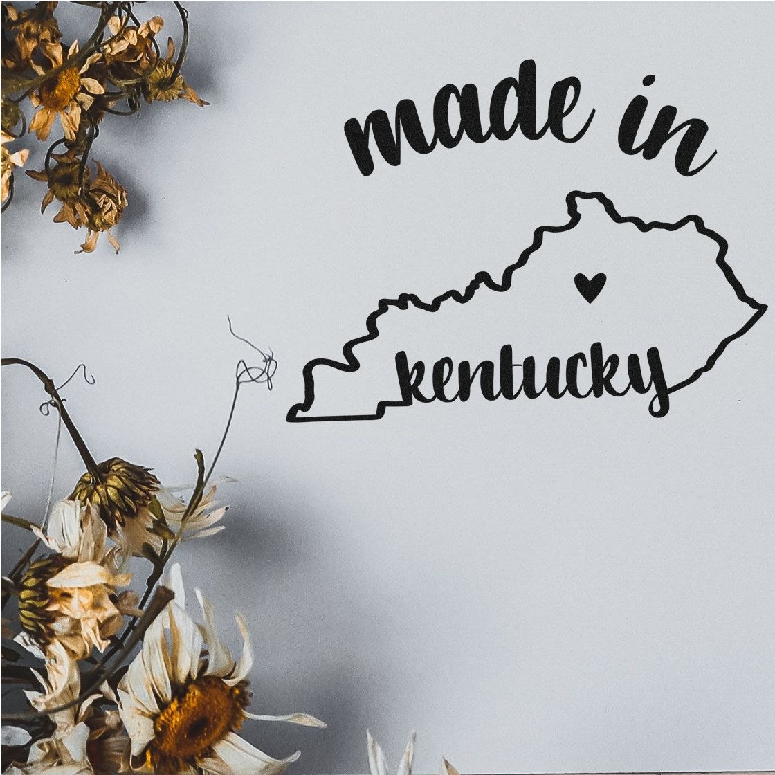 Made in Kentucky Stamp Pre-Inked featuring a black outline of Kentucky with a heart, surrounded by dried flowers on a white background.