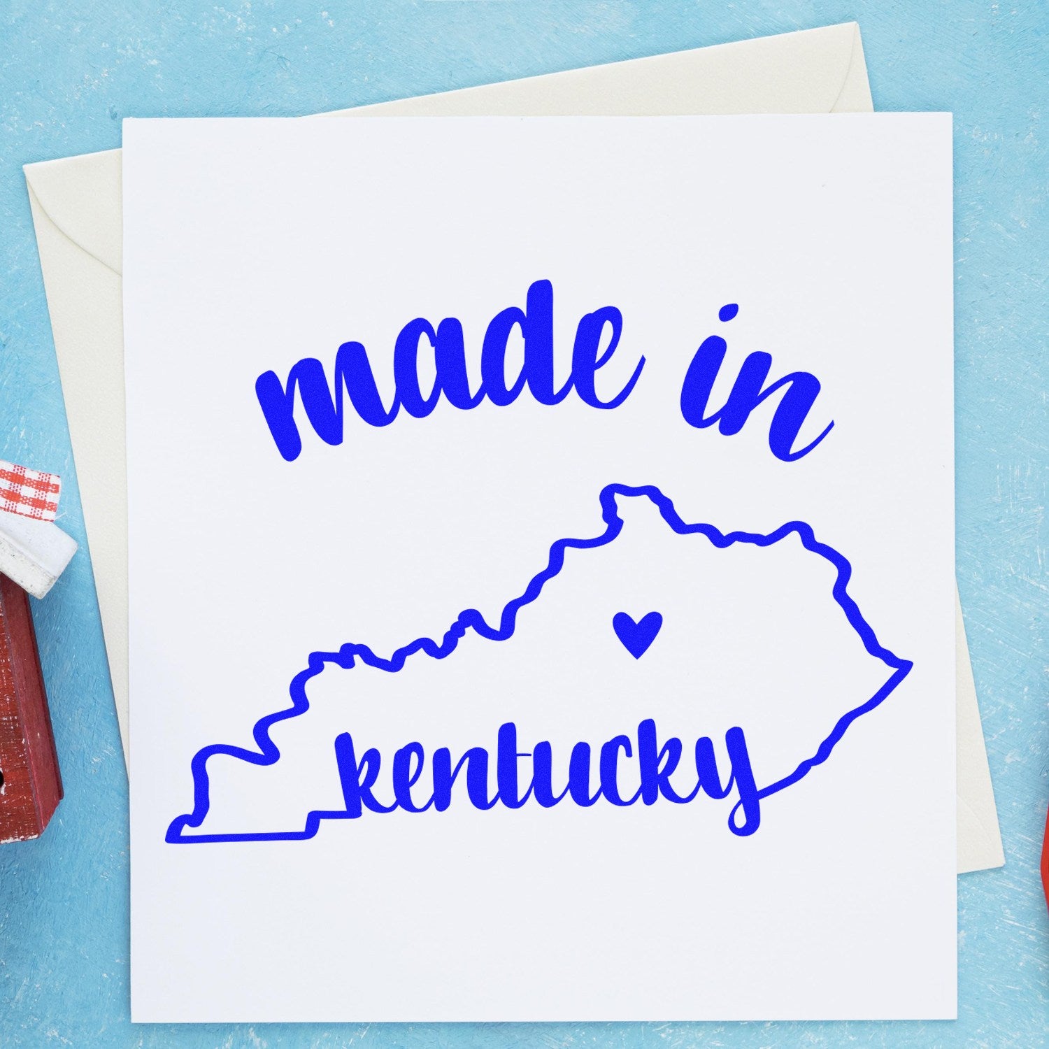 Self-Inking Handmade with Love in Kentucky Stamp featuring a blue outline of Kentucky with 'made in kentucky' text, perfect for crafts and gifts. Includes envelope and rustic decor.