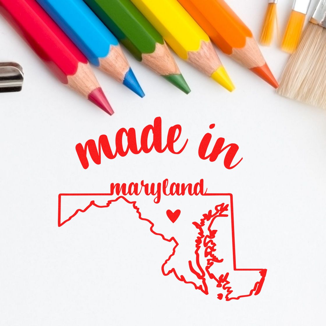 Slim Pre-Inked Stamp Maryland Made in Stamp featuring a red made in Maryland design with a heart and state outline, surrounded by colorful pencils and a paintbrush.