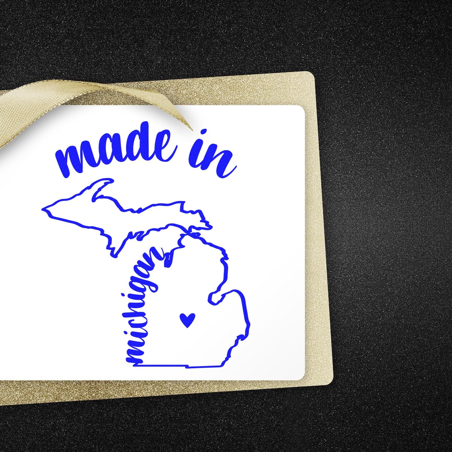 Made in Michigan Stamp Pre-Inked featuring a blue outline of Michigan with 'made in' text, perfect for crafts and branding. Includes a heart symbol on a black and gold background.