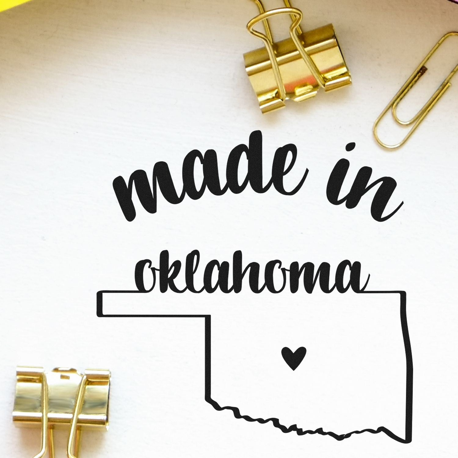 Self-Inking Handmade with Love in Oklahoma Stamp featuring a heart inside the state outline, surrounded by gold binder clips on a white background.