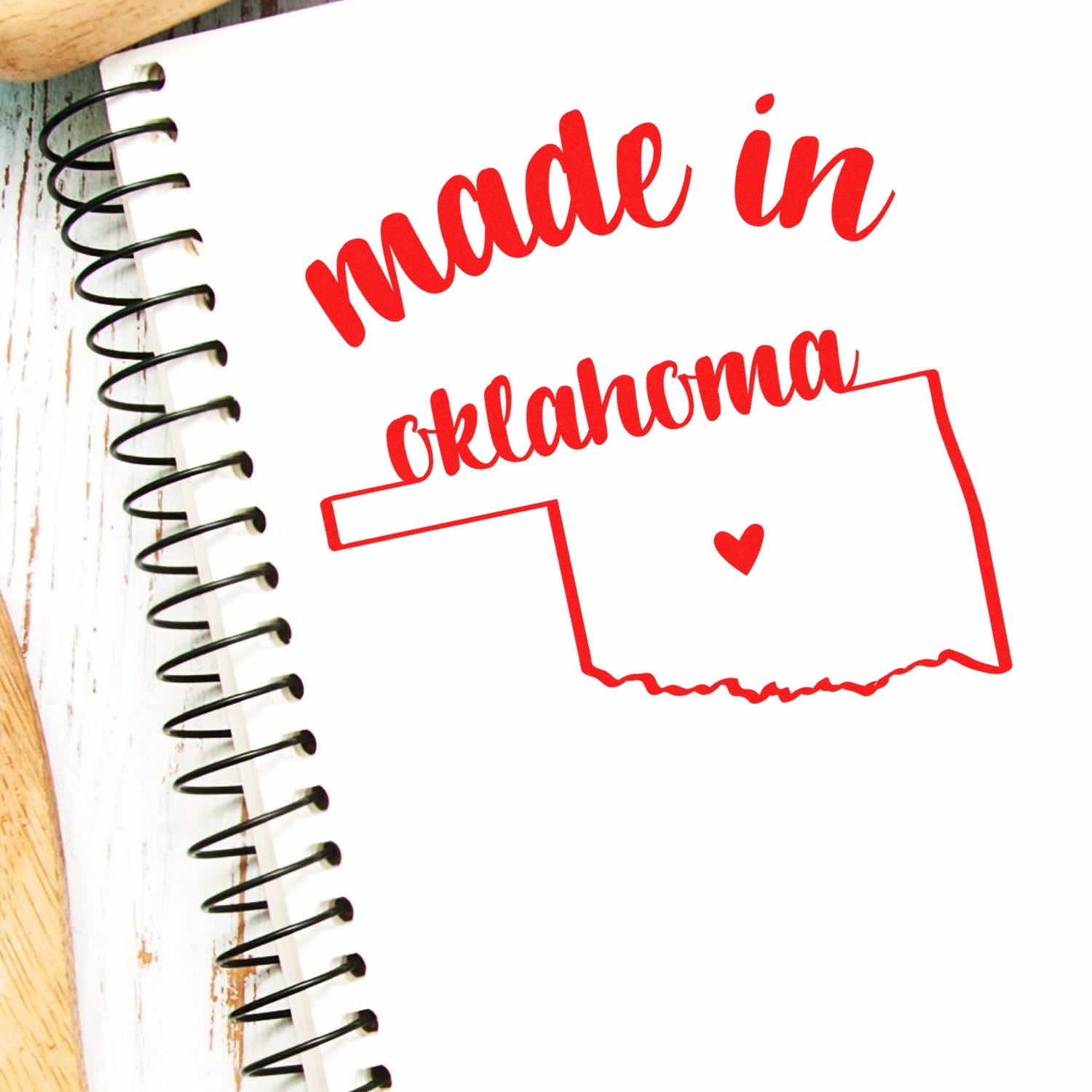 Slim Pre-Inked Stamp Oklahoma Made in Stamp featuring a red outline of Oklahoma with 'made in oklahoma' text and heart design on a spiral notebook.