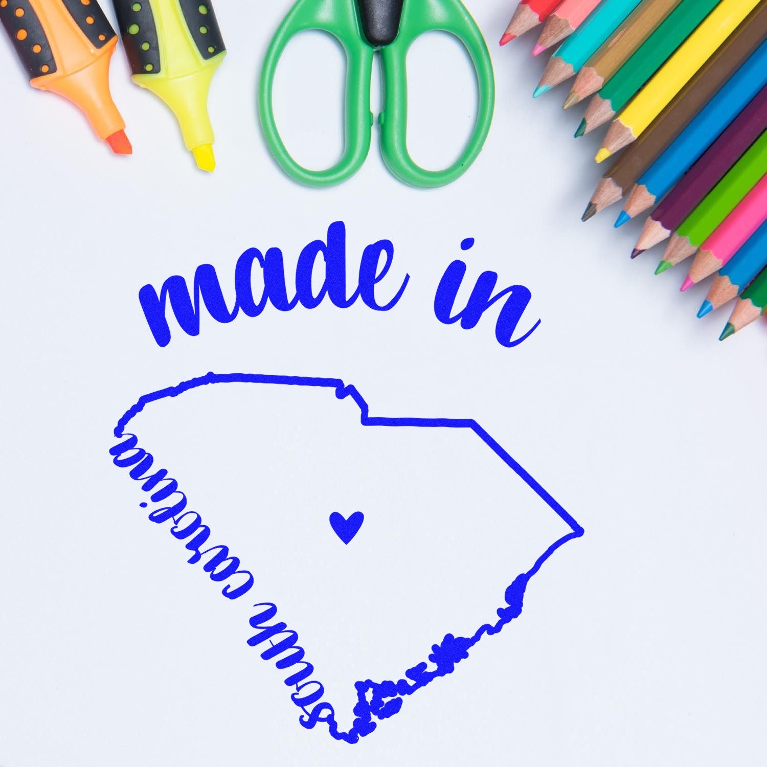 Self-Inking Handmade with Love in South Carolina Stamp featuring a blue state outline with a heart, surrounded by colorful markers and scissors. Perfect for crafts and personalized projects.