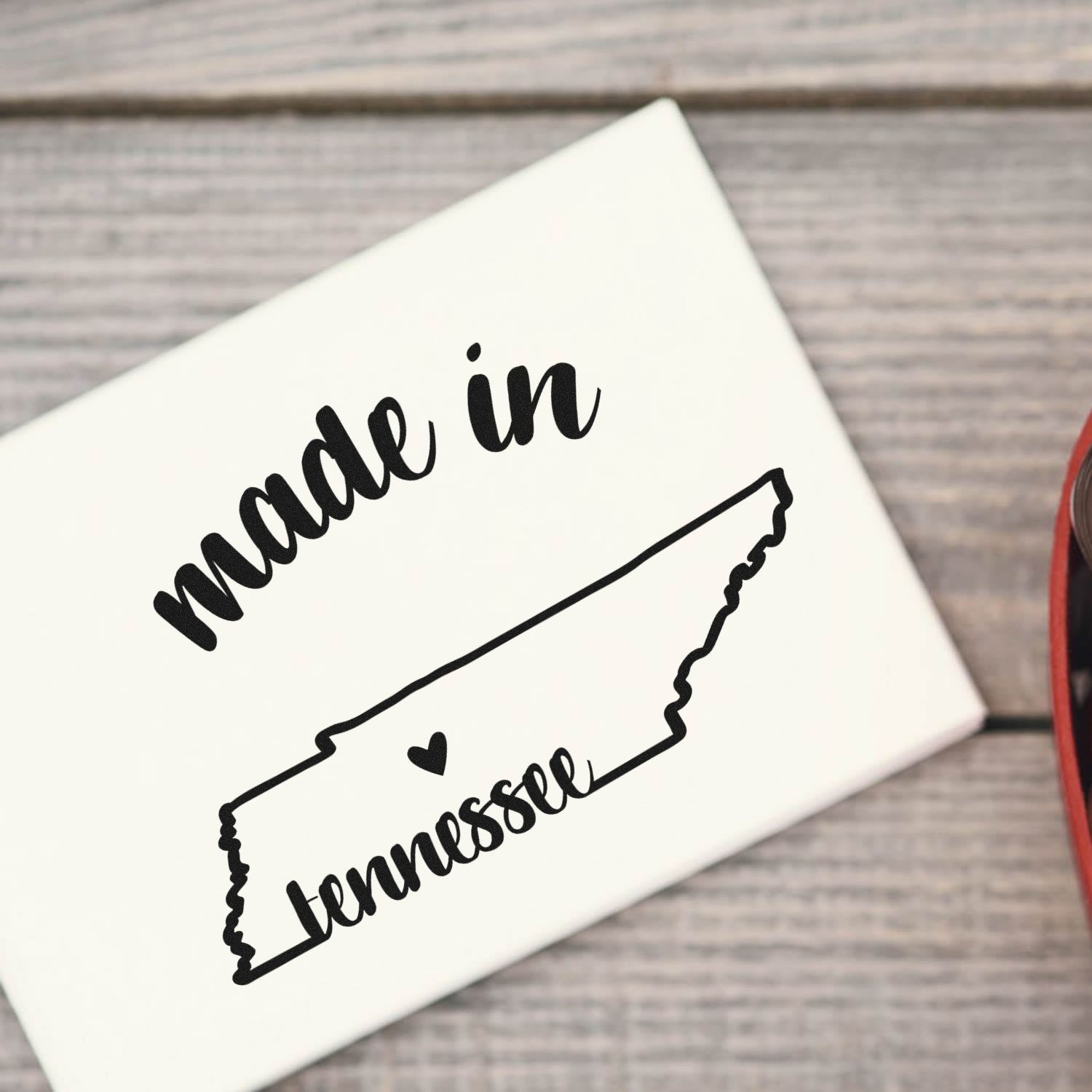 Made with Love in Tennessee Rubber Stamp featuring a heart and state outline design on a wooden surface.