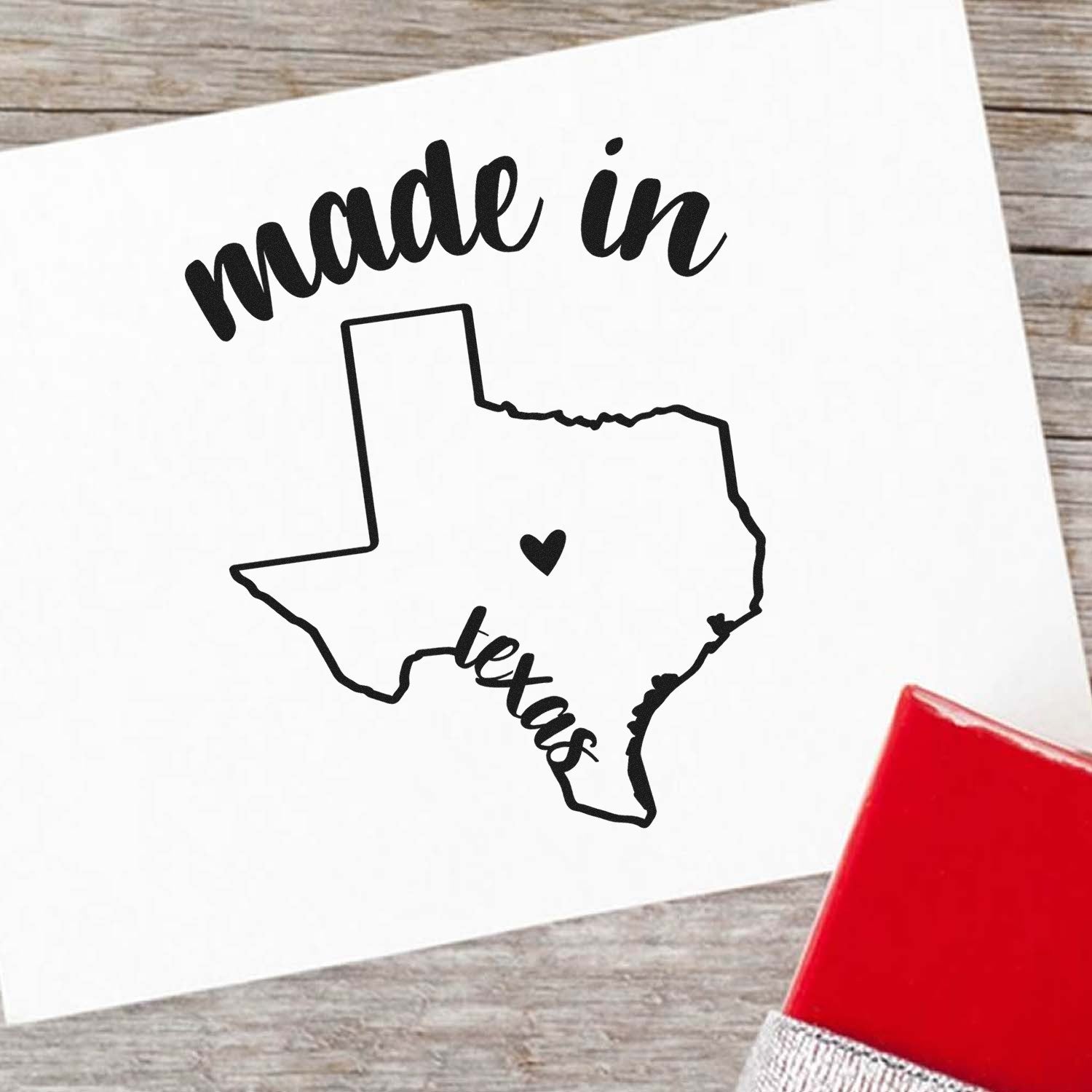 Self-Inking Handmade with Love in Texas Stamp featuring a Texas outline with heart, 'made in Texas' text, and red stamp base on a wooden surface.