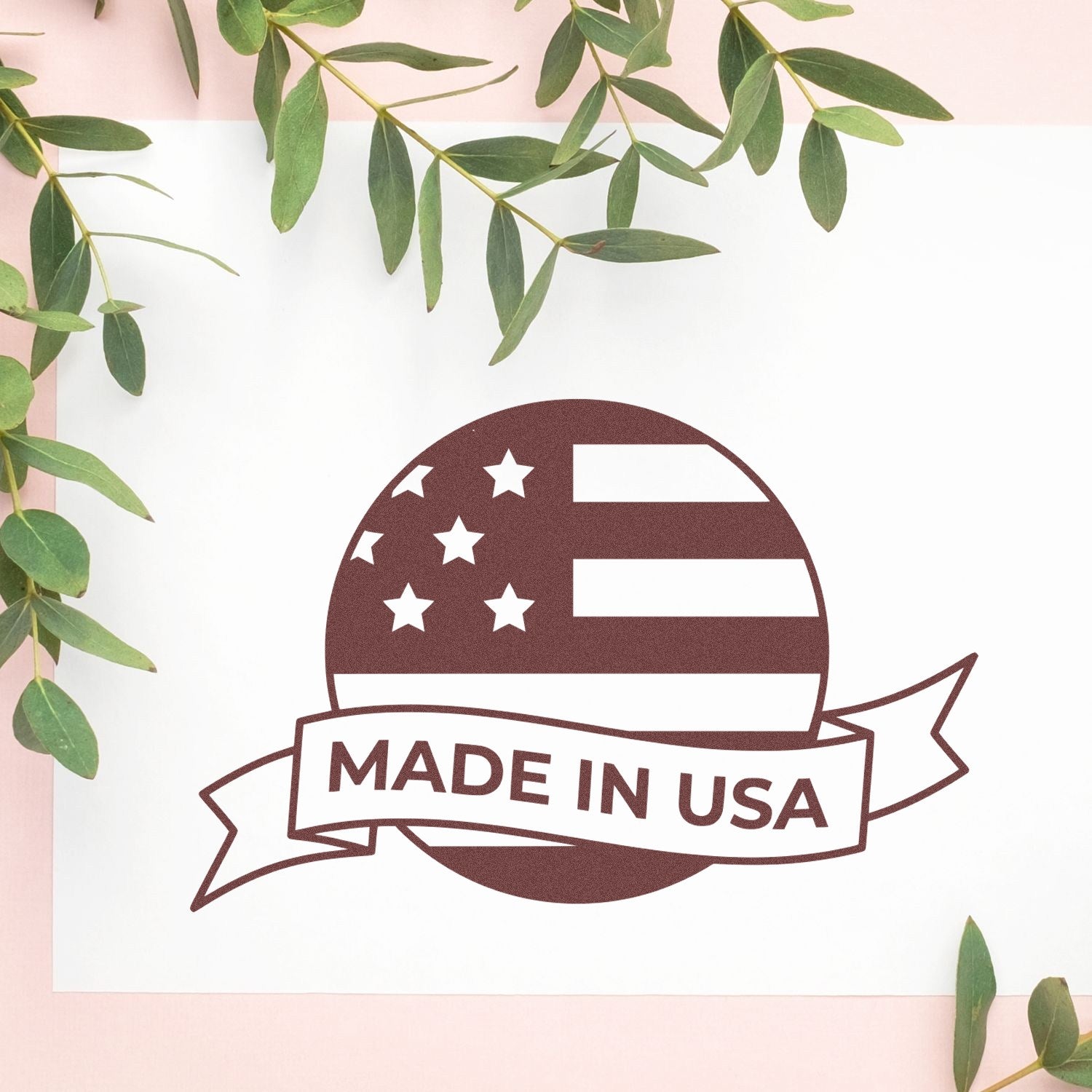 Slim Pre-Inked Patriot Seal Of Quality Stamp featuring a Made in USA design with stars and stripes, displayed on a white background with green leaves. Ideal for authenticating products.