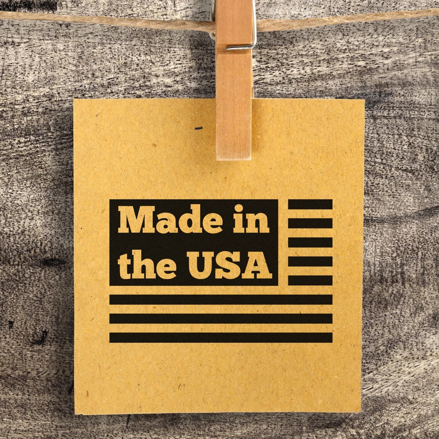 Slim Pre-Inked Patriotic Pride Made in the USA Stamp on a rustic background, featuring bold black text and stripes on a brown card, clipped to a string. Perfect for showcasing American craftsmanship.