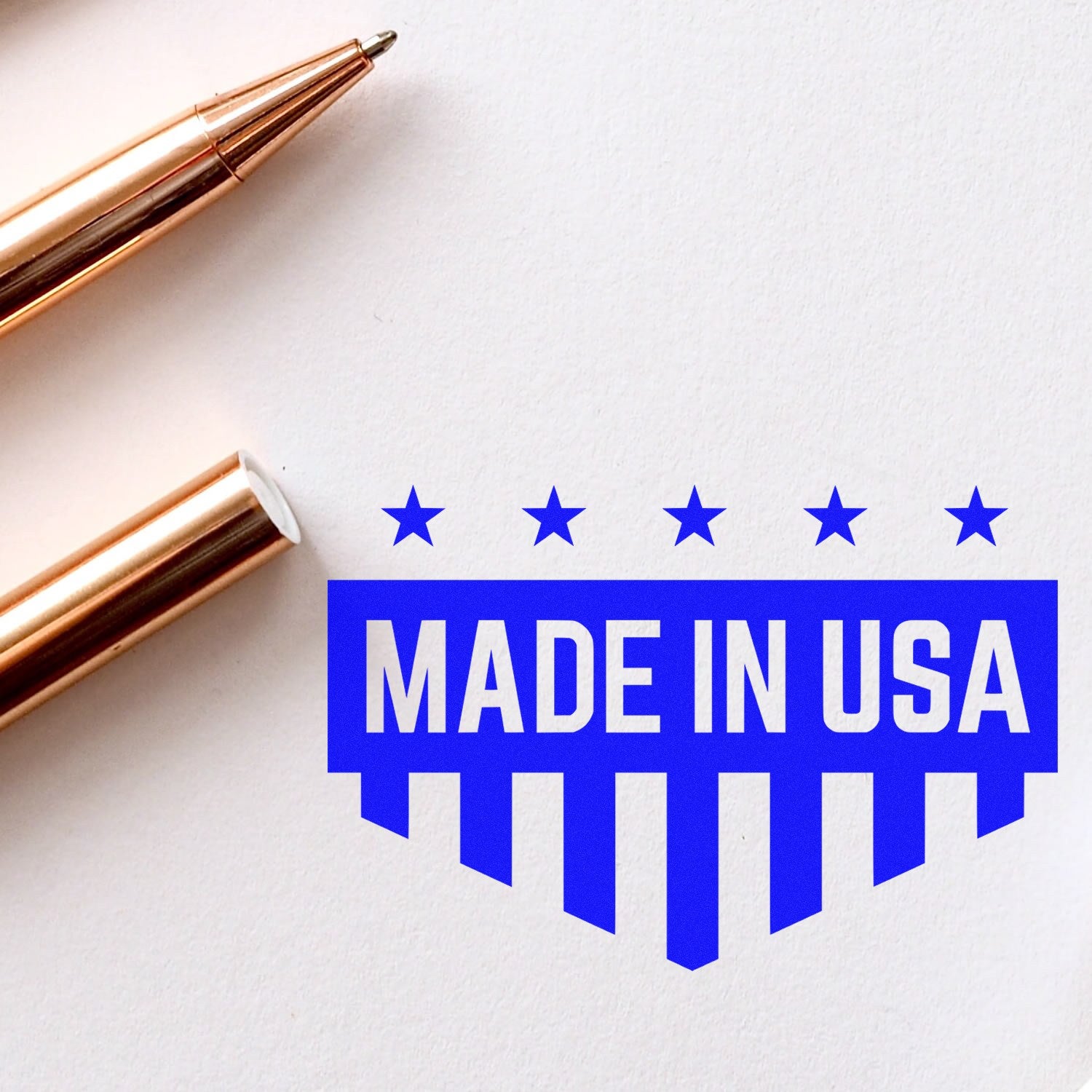 Slim Pre-Inked Patriotic Quality Seal Stamp with Made in USA design in blue, featuring stars and stripes, next to a gold pen on white paper. Ideal for adding a patriotic touch to documents.