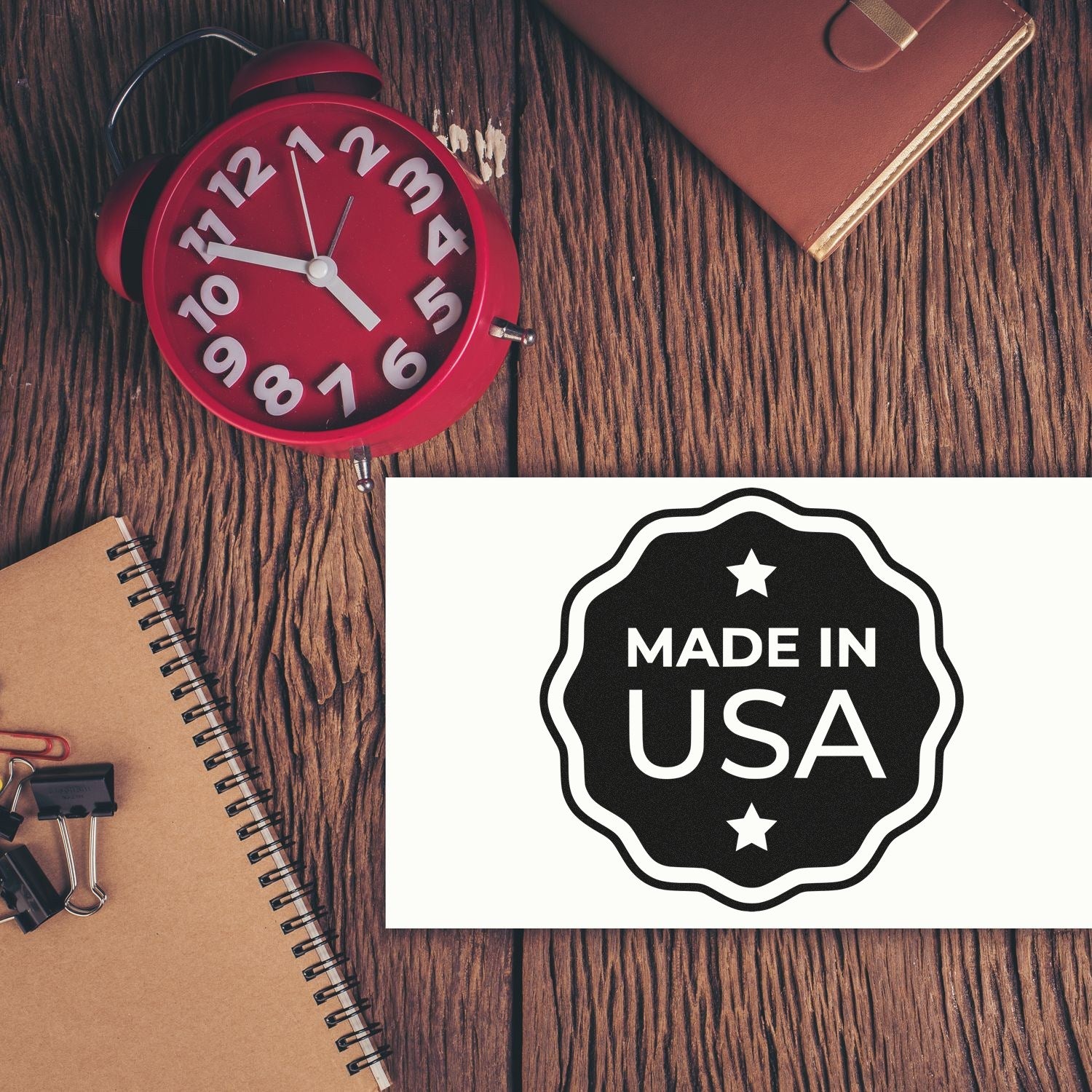 Wood Handle USA Craftsmanship Seal Rubber Stamp on a wooden table with a 'Made in USA' imprint, surrounded by a red clock, notebook, and leather wallet.