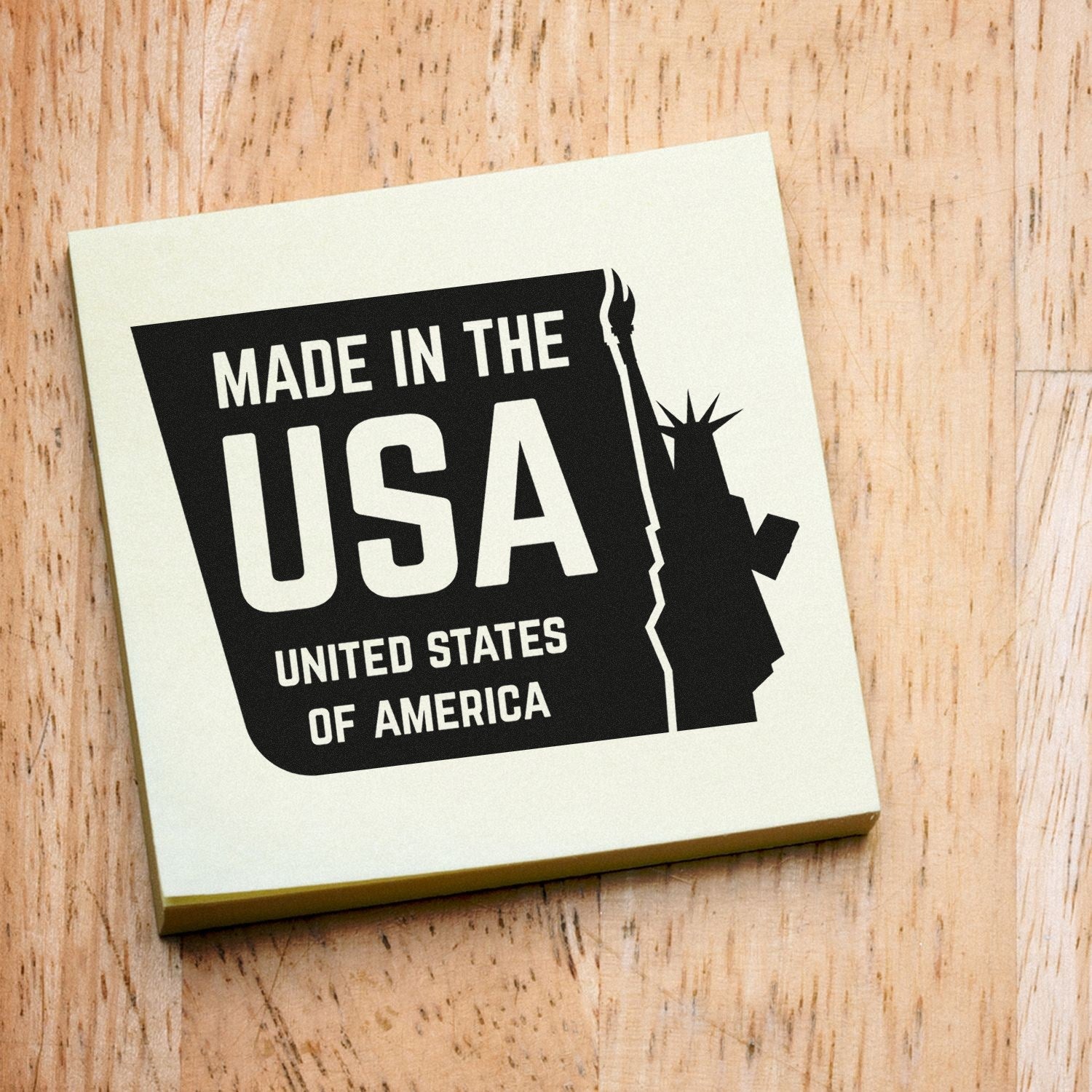 Image of a PSI Pre-Inked Liberty Made USA Stamp on a wooden surface, featuring a bold Made in the USA design with the Statue of Liberty silhouette. Perfect for patriotic branding.