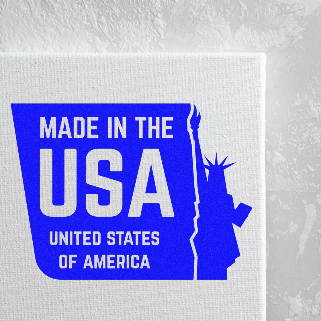 Wood Handle Liberty Made USA Rubber Stamp imprint on white surface, featuring bold blue Made in the USA text with a silhouette of the Statue of Liberty.