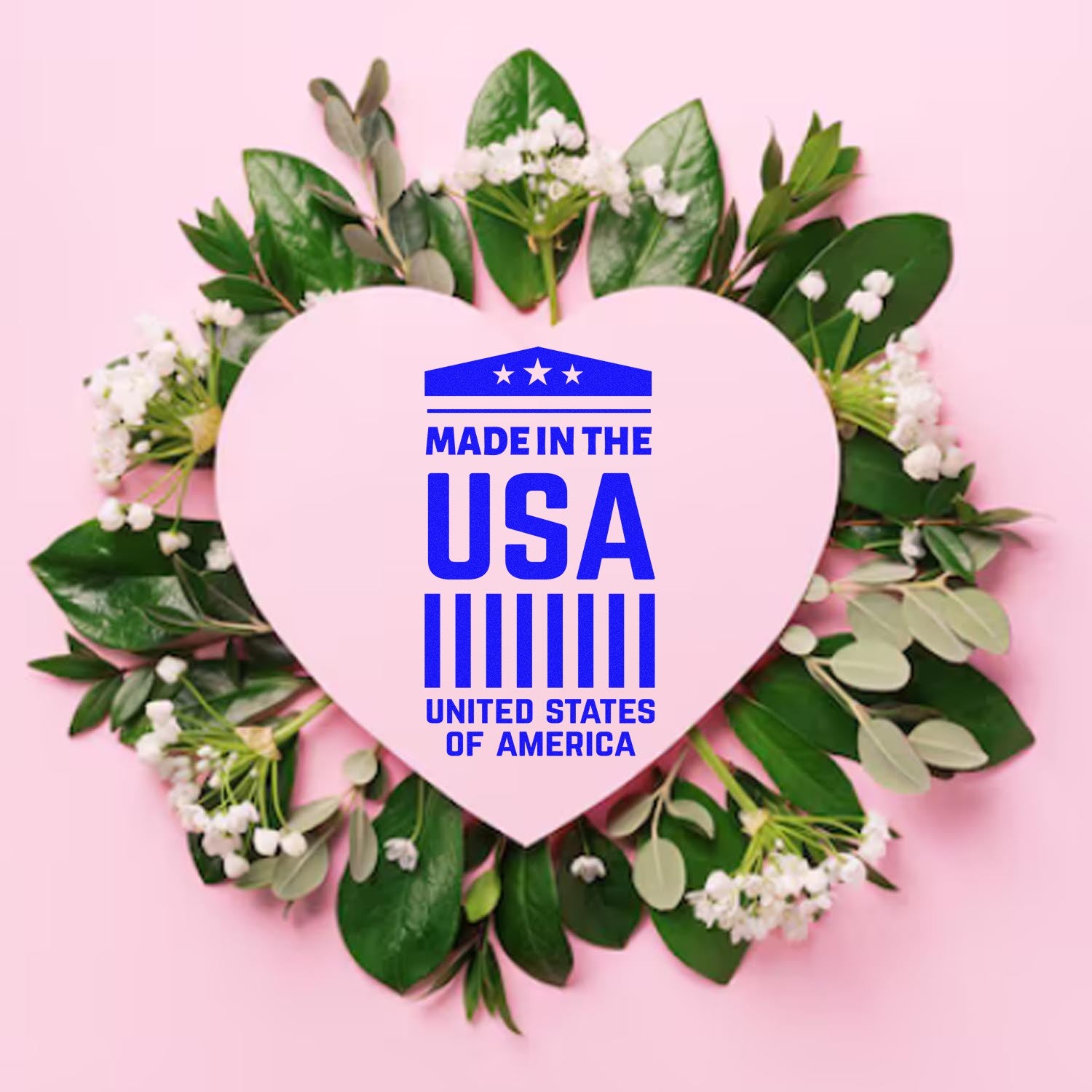 Slim Pre-Inked American Pride Emblem Stamp on a pink heart surrounded by green leaves and white flowers, featuring Made in the USA text in blue. Perfect for patriotic crafts and documents.