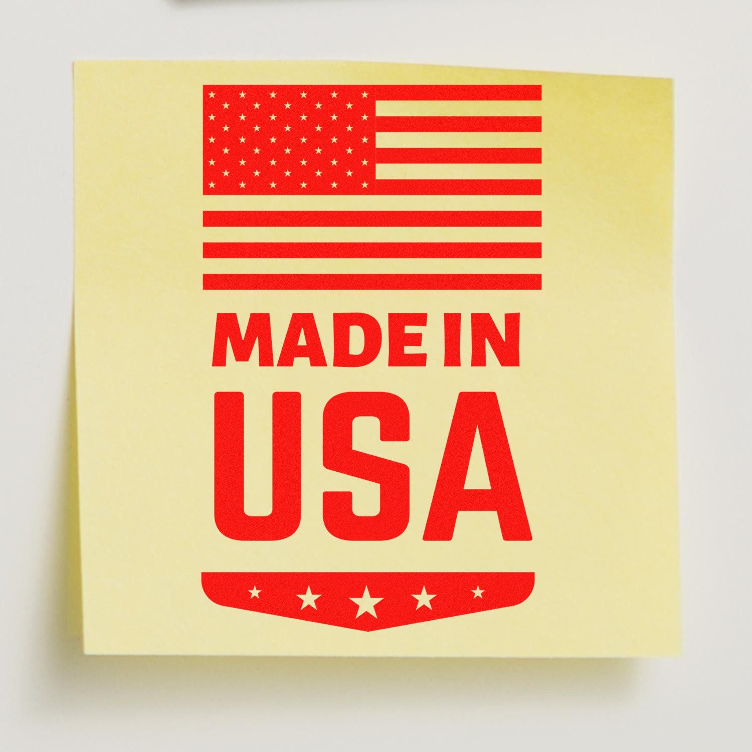 PSI Pre-Inked Made In USA Emblem Stamp on yellow paper, featuring a red American flag and bold Made in USA text, ideal for marking products with a patriotic touch.