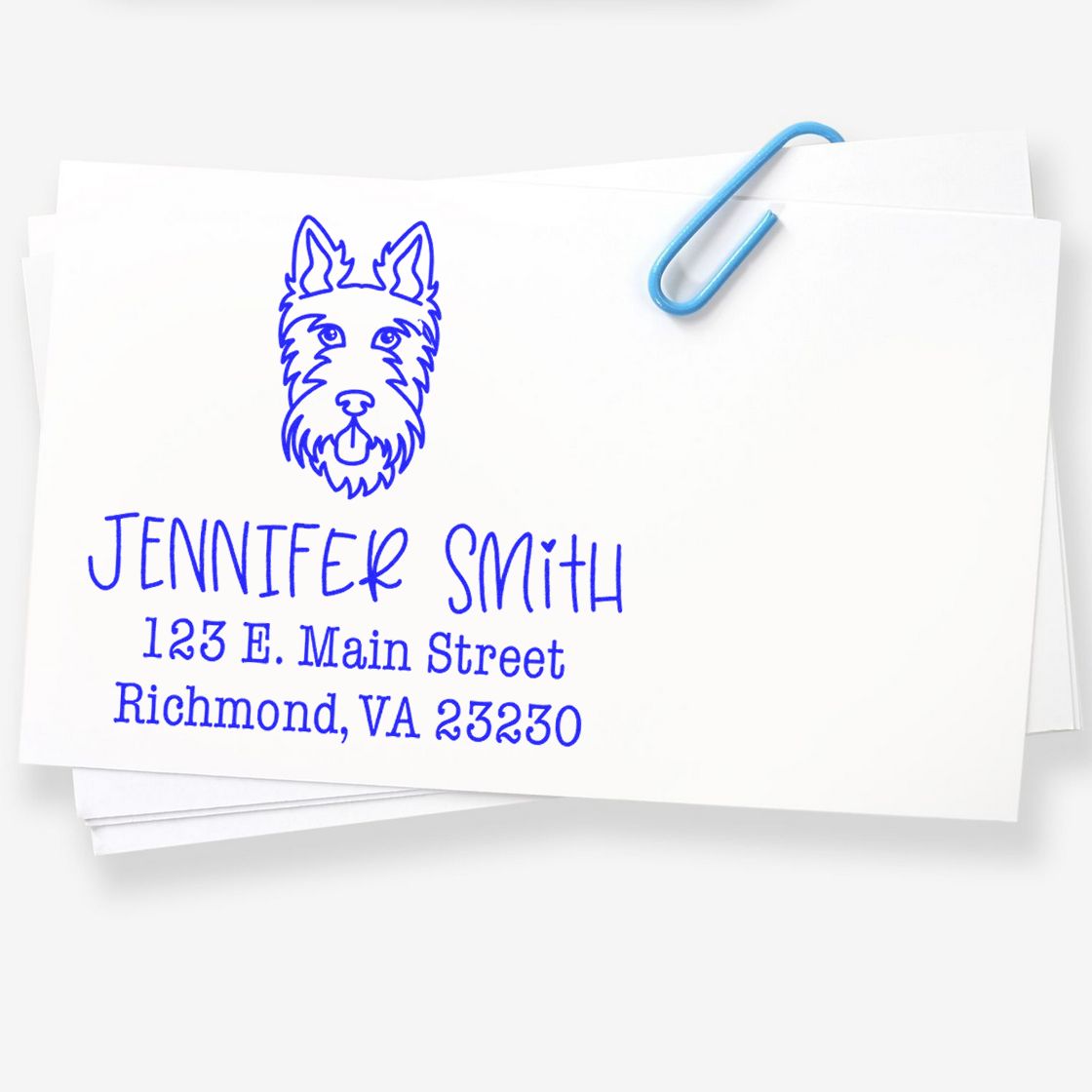 Blue custom address stamp with dog seal, Jennifer Smith, and Richmond, VA address on white paper, clipped with a blue paperclip.