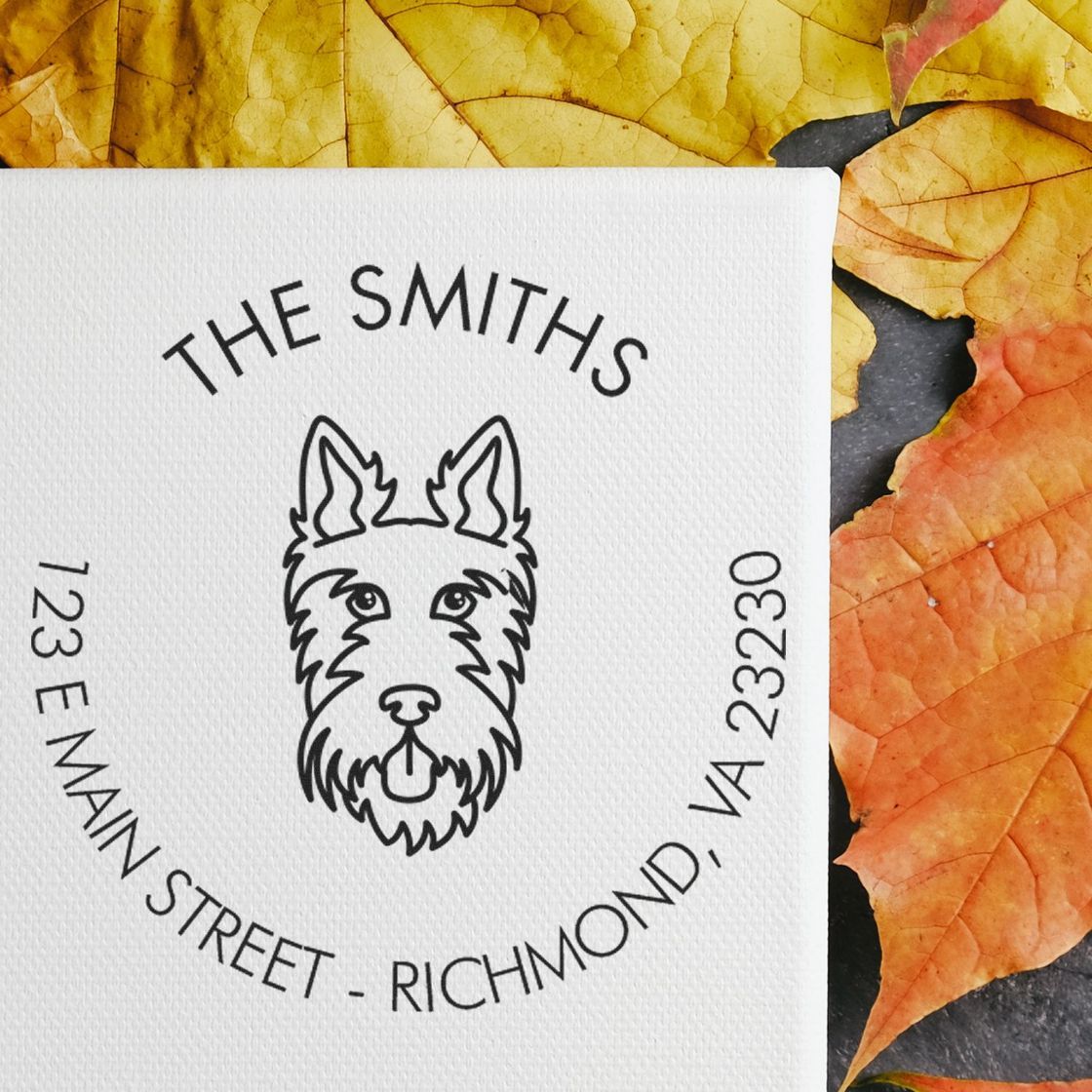 Black custom stamp seal with dog logo and The Smiths text on a white textured card, set on yellow-orange autumn leaves.