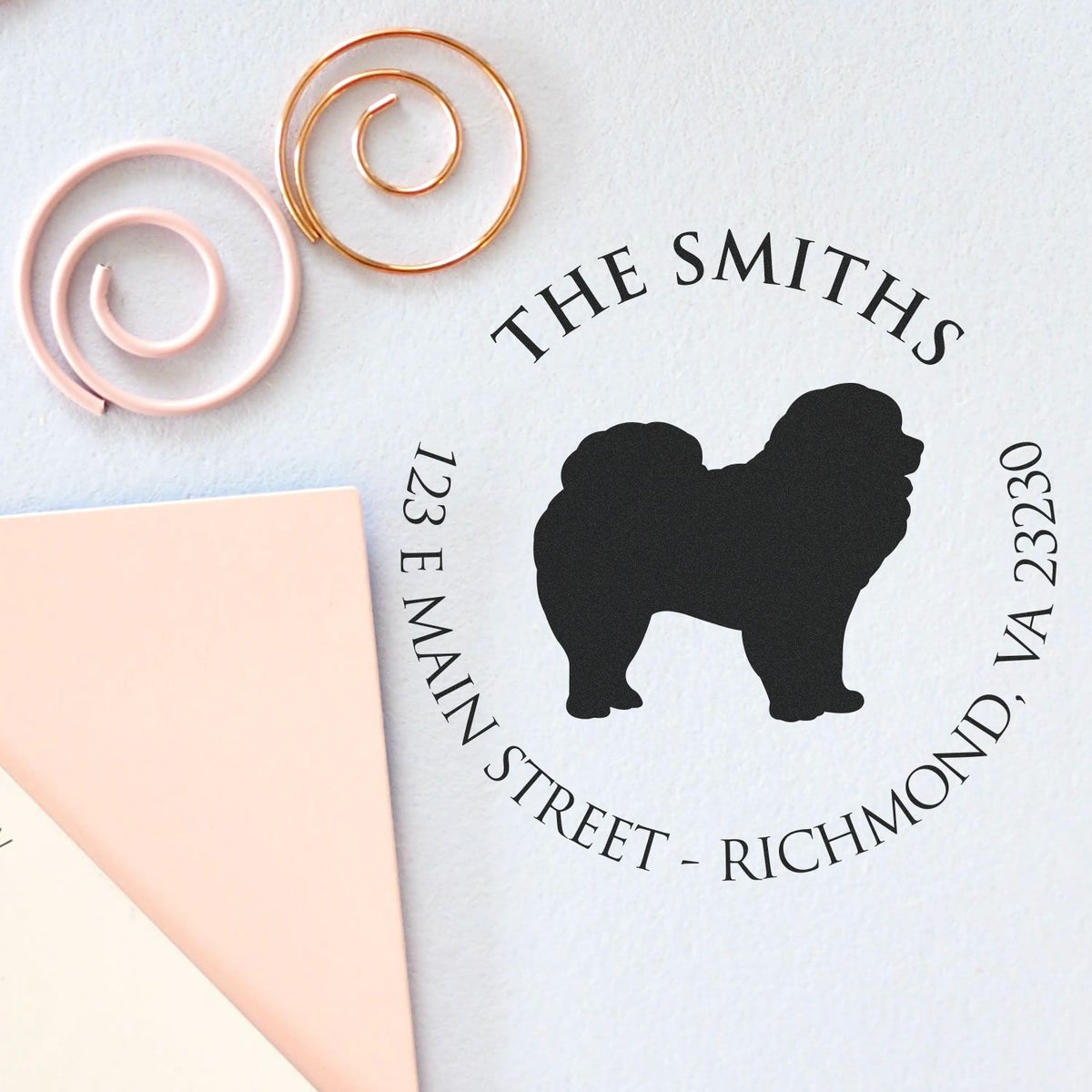 Custom stamp and seal mockup with black dog silhouette, black text, and pink and gold metal tools on white background.